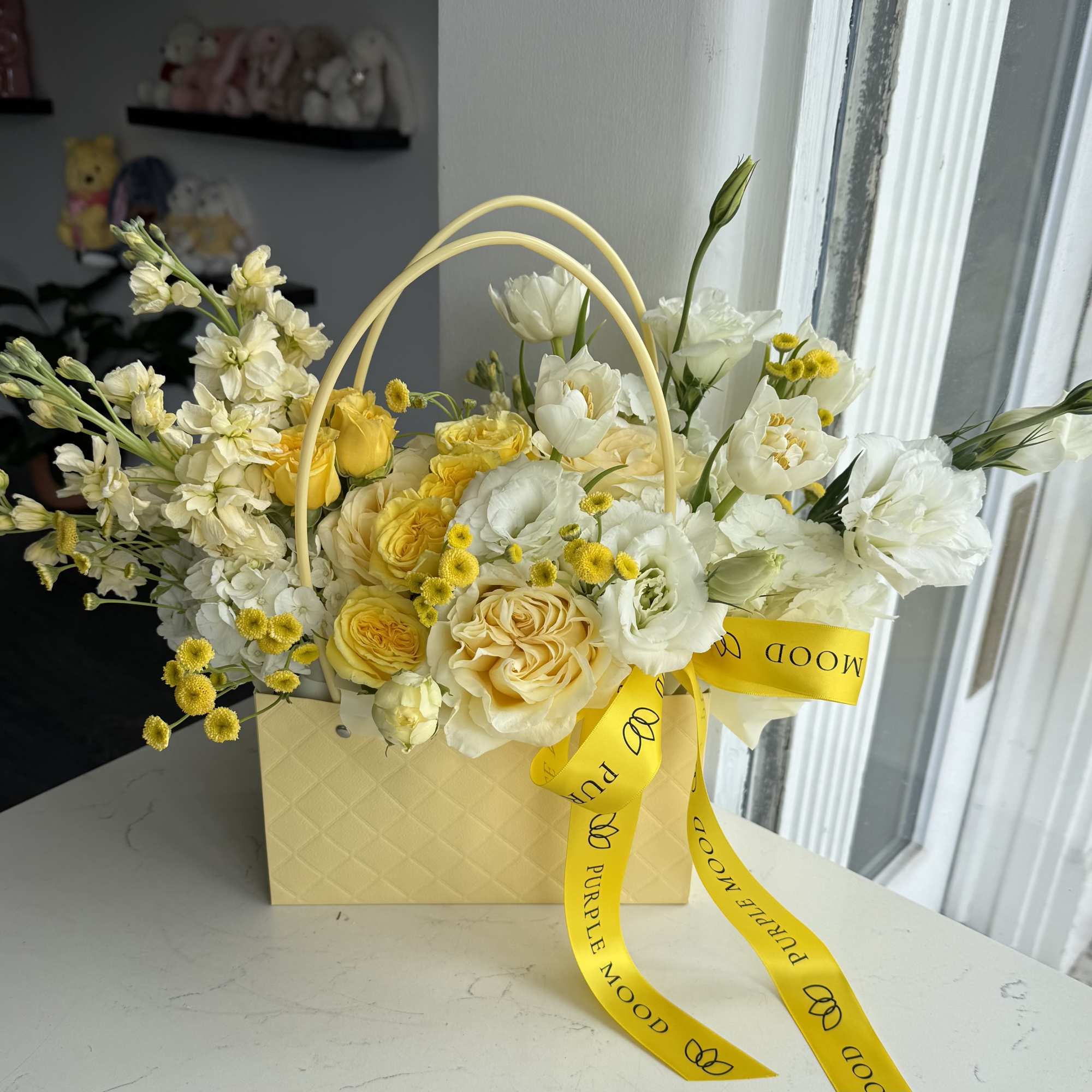A bright and cheerful spring arrangement designed in our elegant mini handbag
