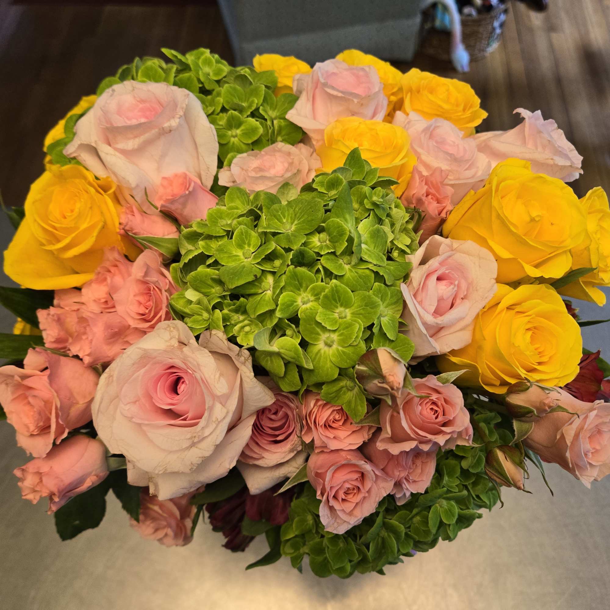 Bouquet of pink and yellow roses with green hydrangeas