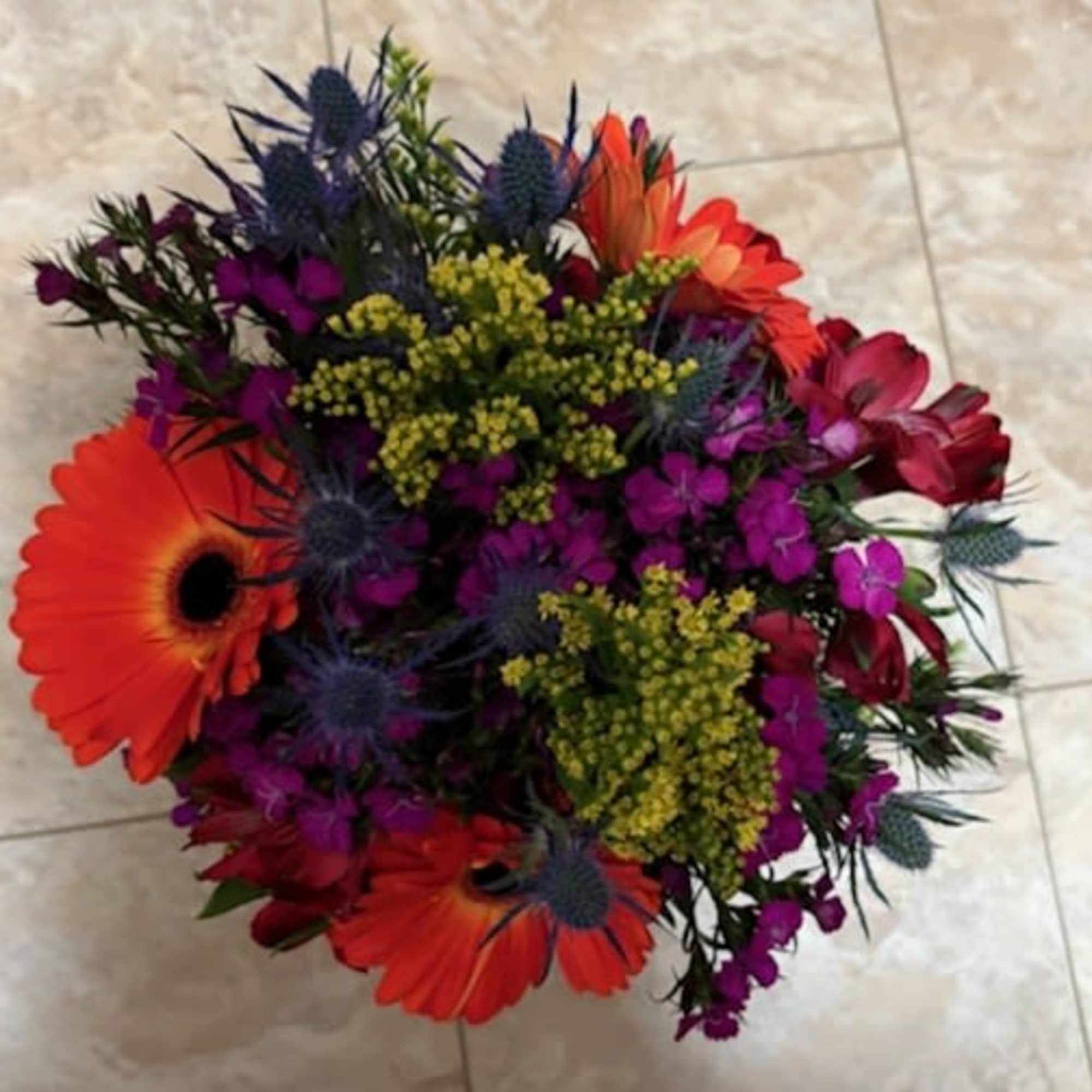Bright mixed bouquet with orange gerbera daisies and purple flowers