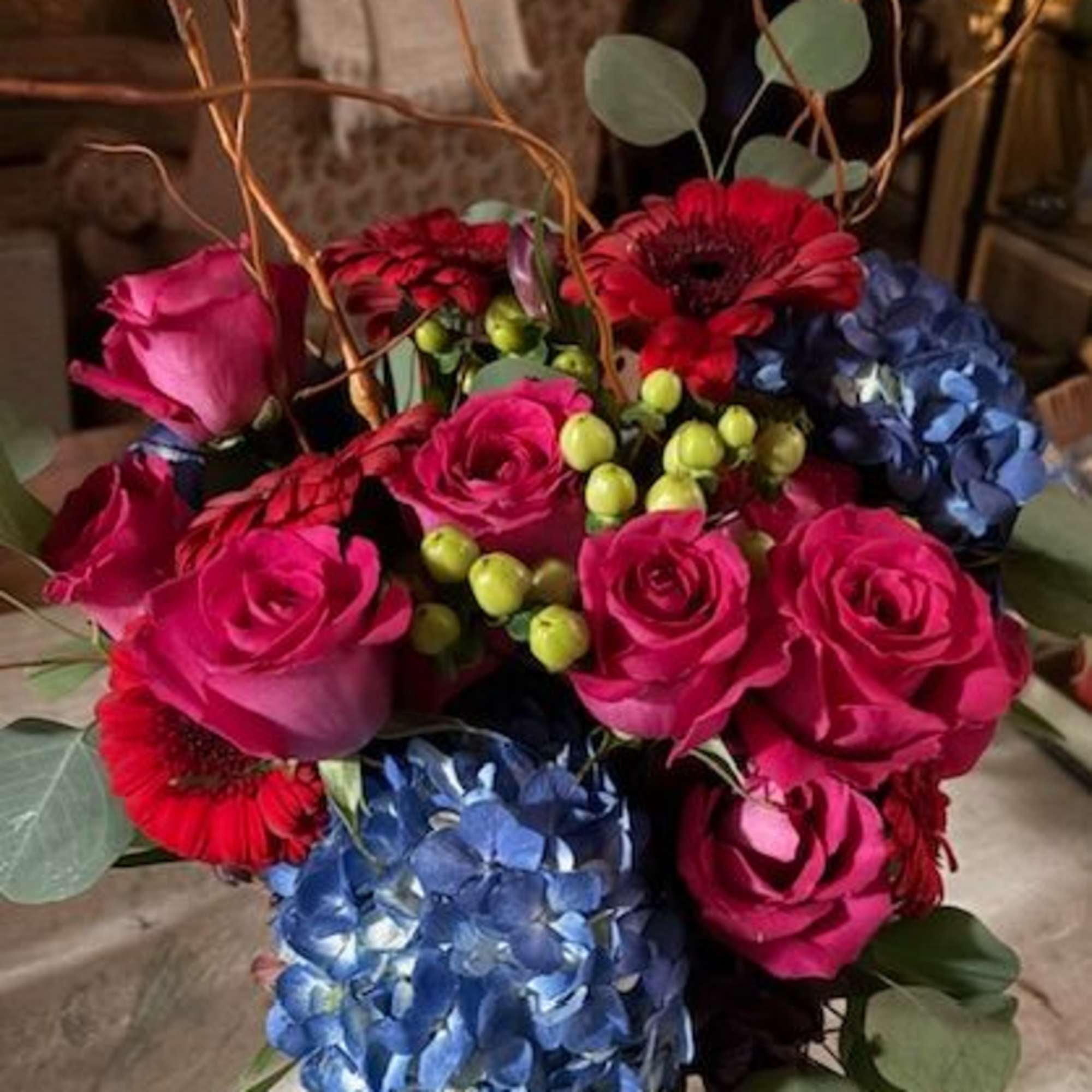 Bouquet of pink roses, red gerberas, and blue hydrangeas in a glass vase, photo 2 of 2