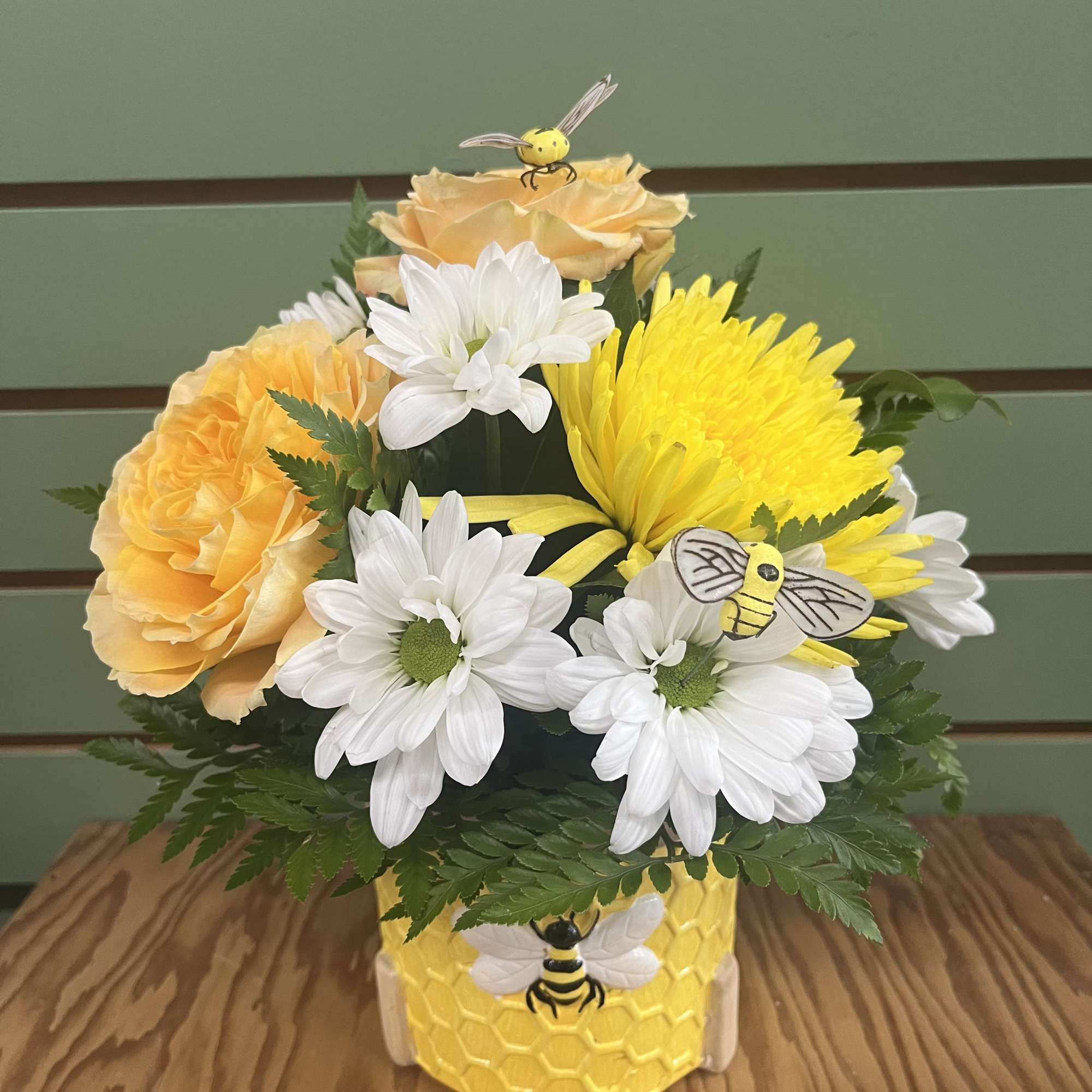 Sunlit yellow roses and bright yellow chrysanthemums mingle with crisp white daisies