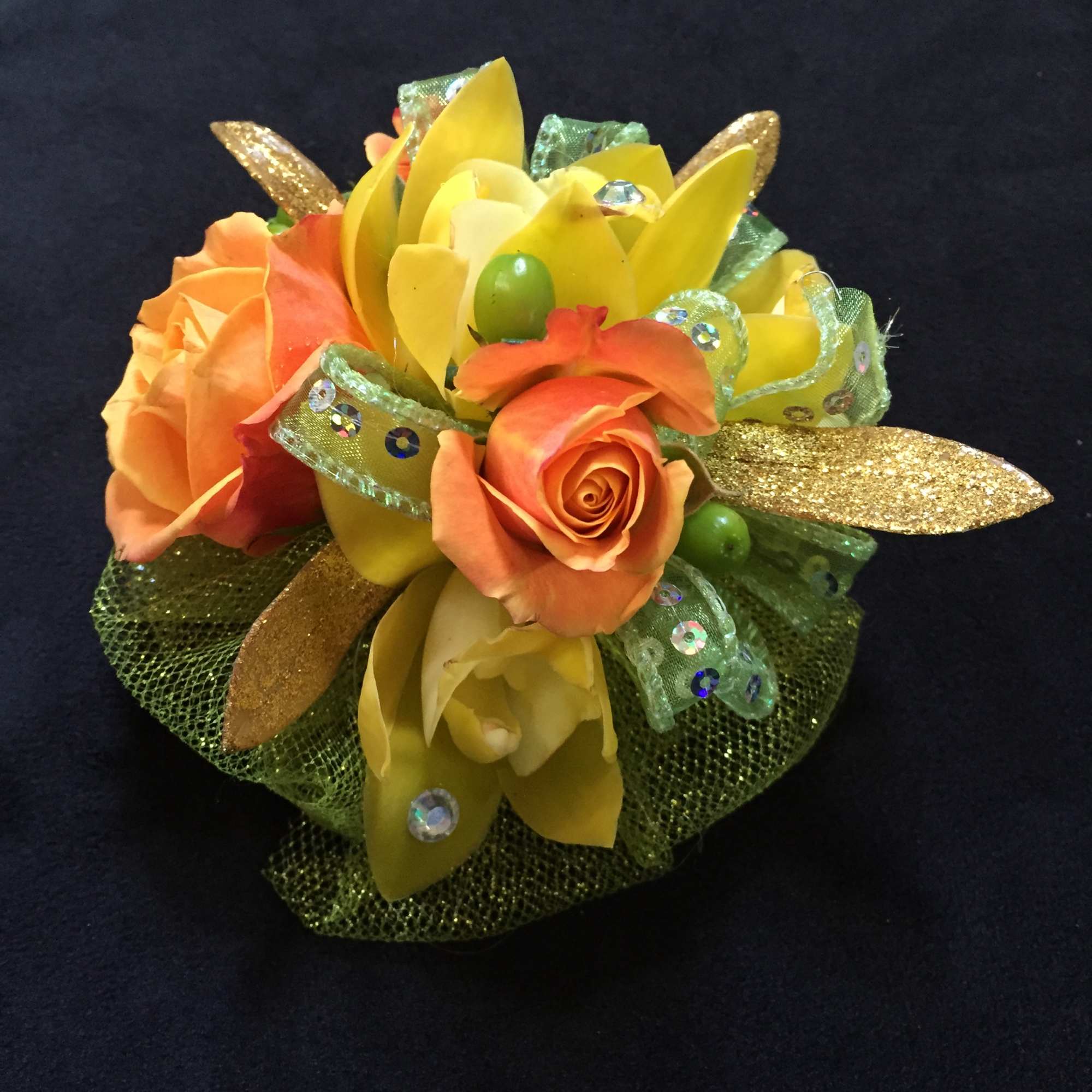 Orange roses with yellow petals and glittery ribbon accents