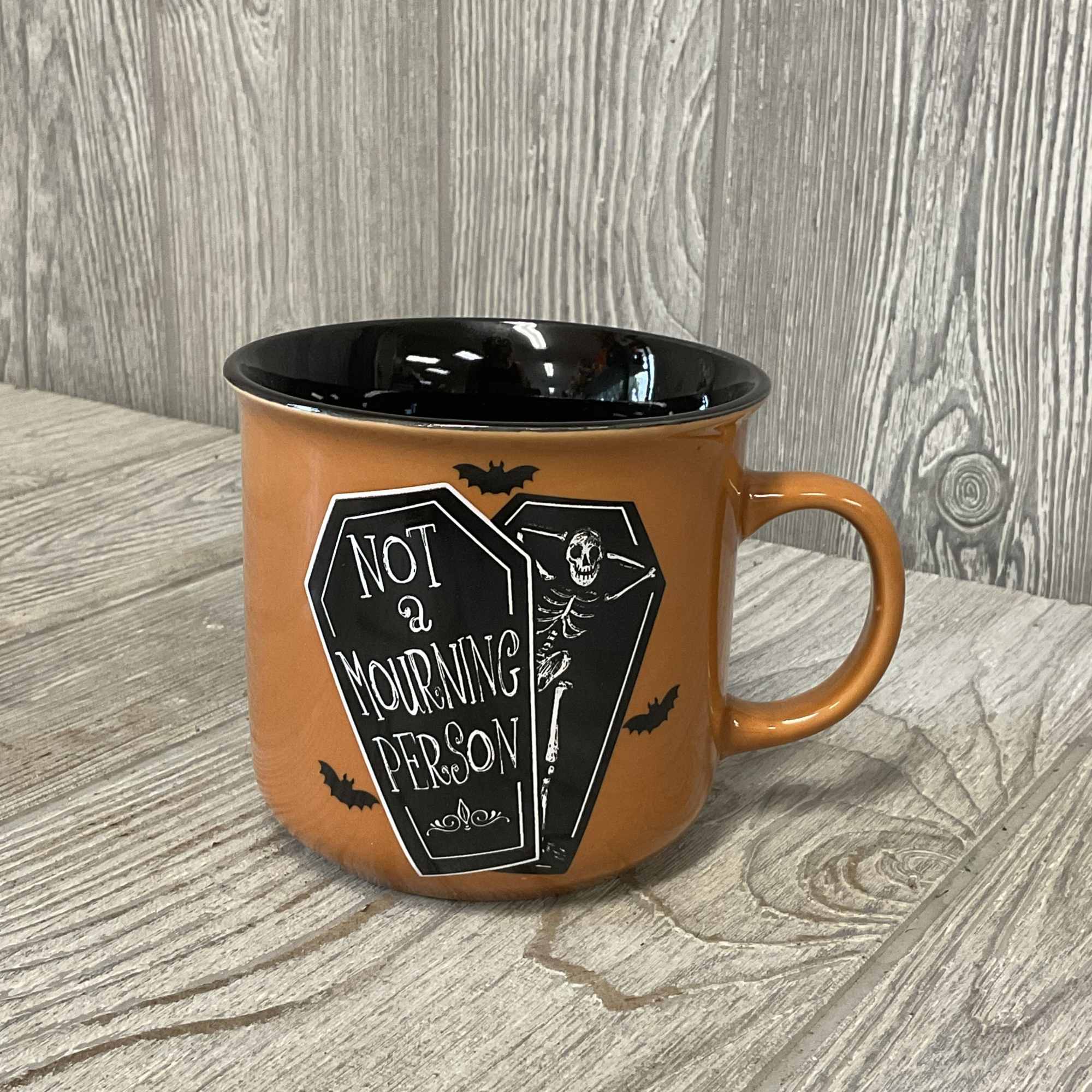 Orange Halloween mug with a black interior and coffin graphic