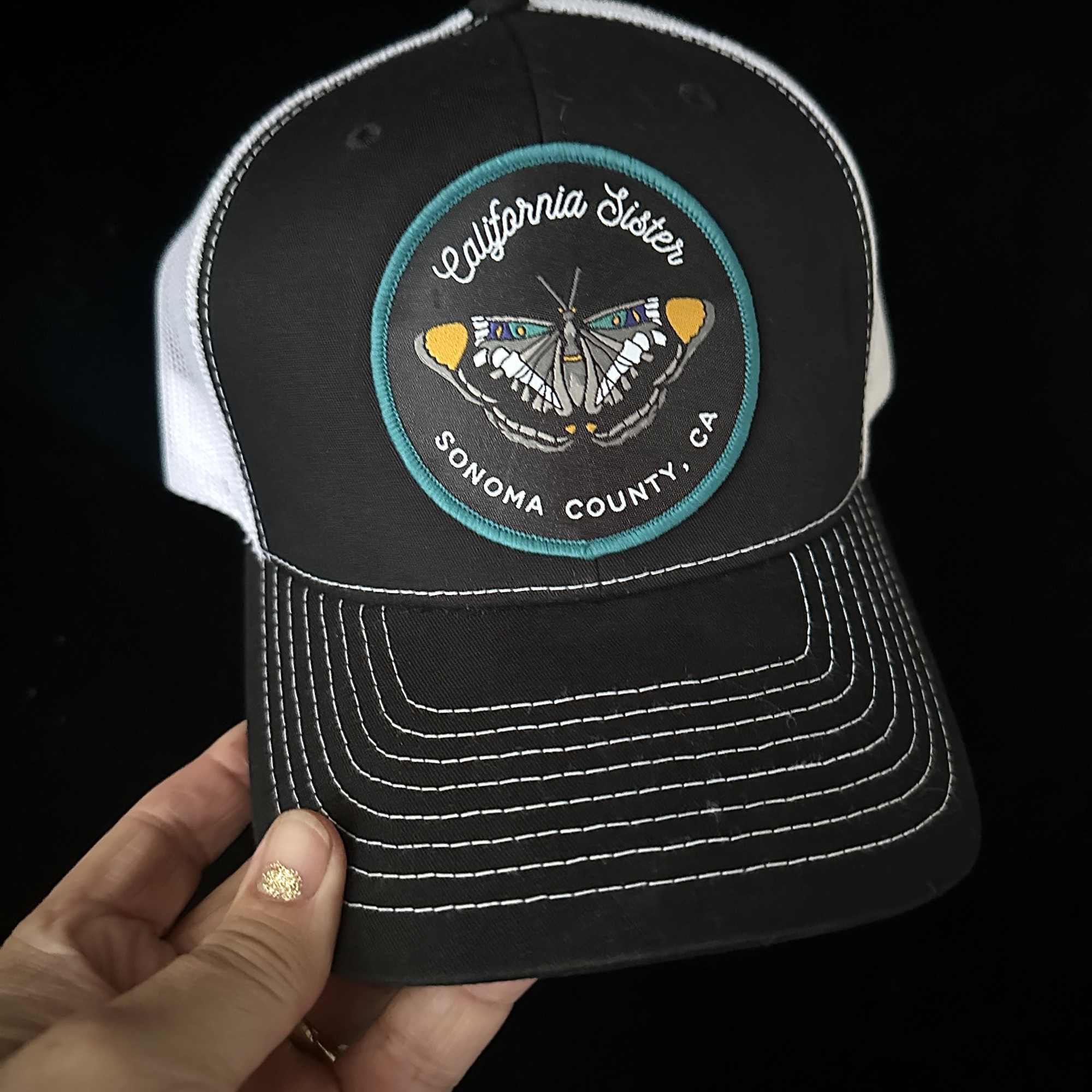 California Sister patch on a white mesh Trucker  ball cap. SnapBack