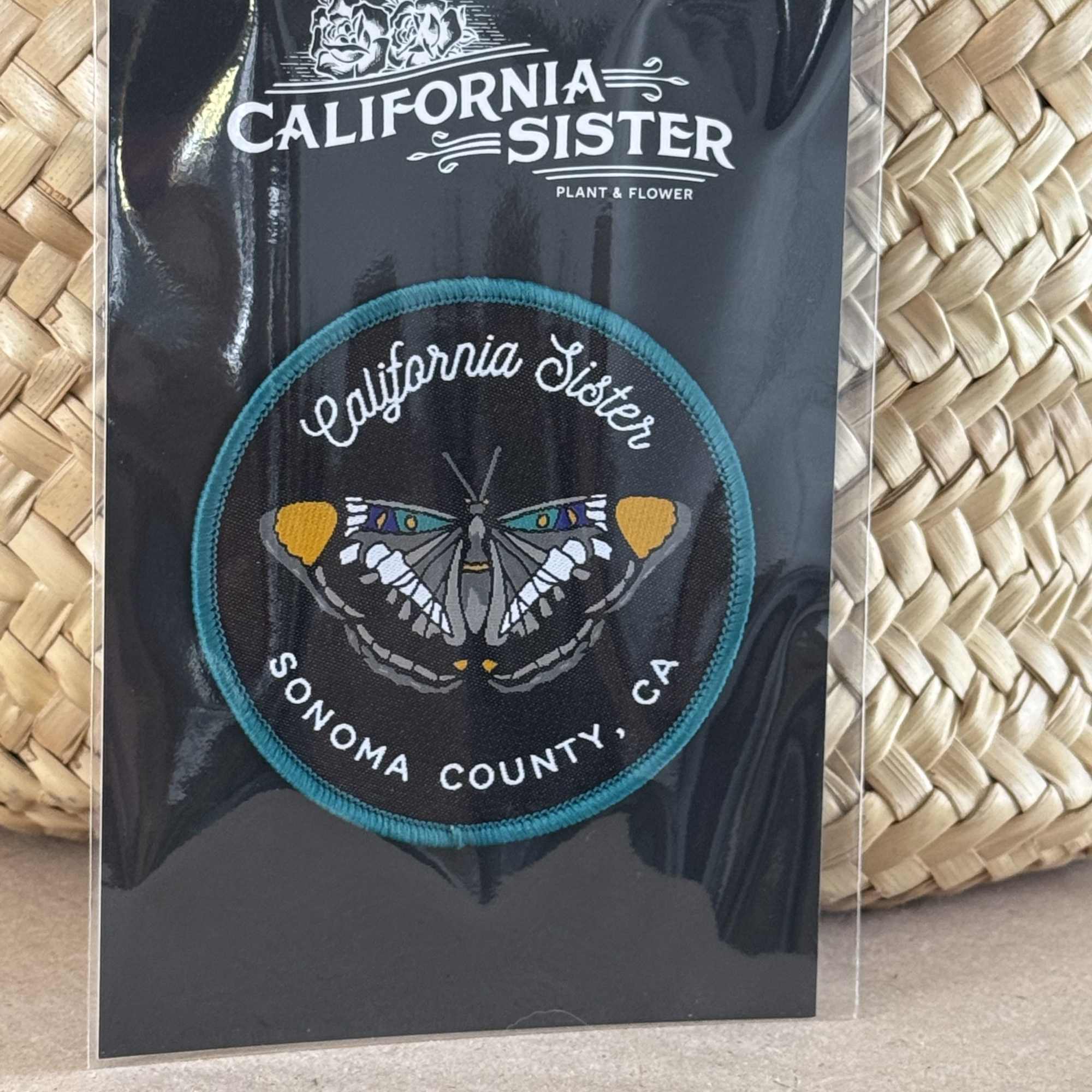 Embroidered California Sister butterfly patch on black packaging