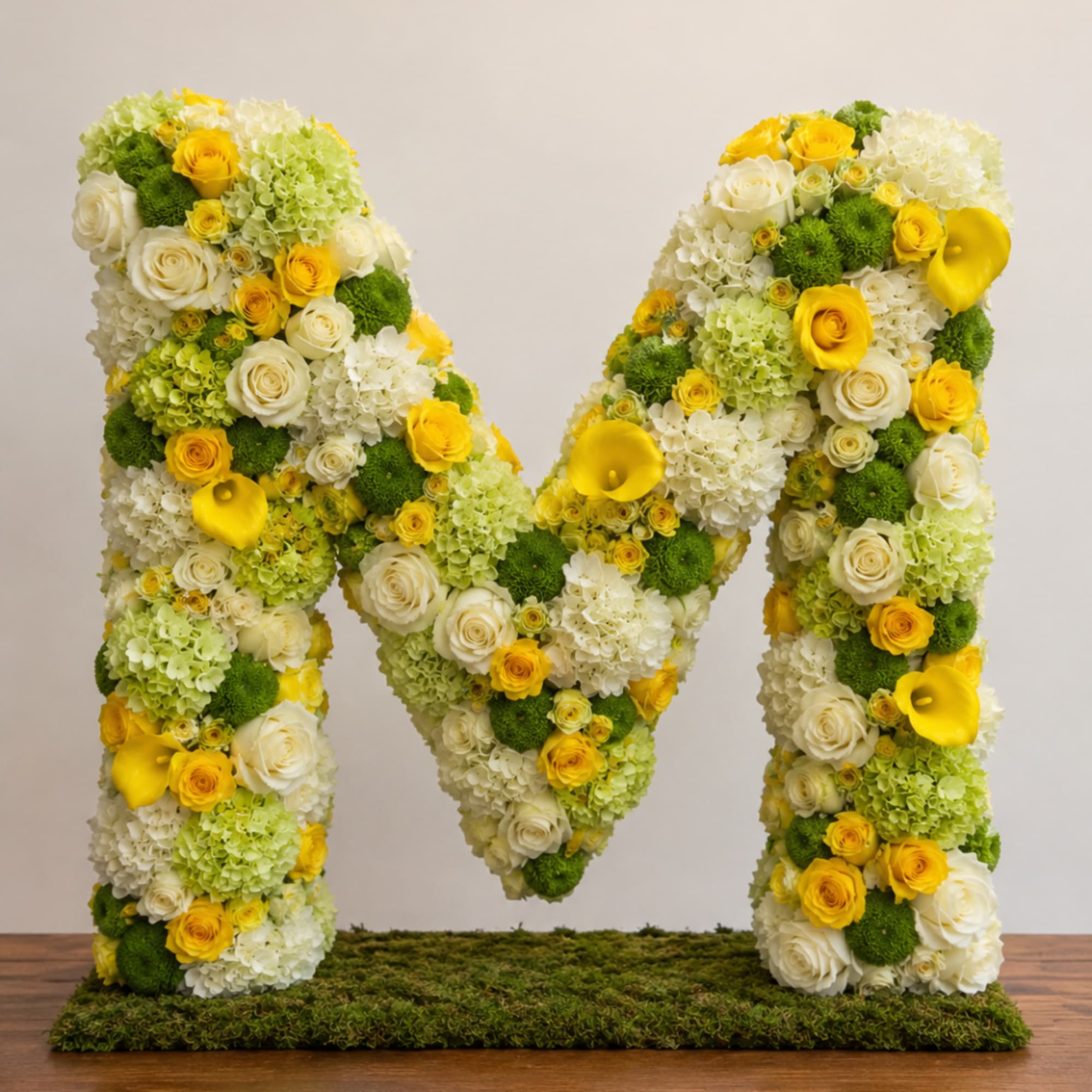 Large floral letter M made of yellow, white, and green blooms