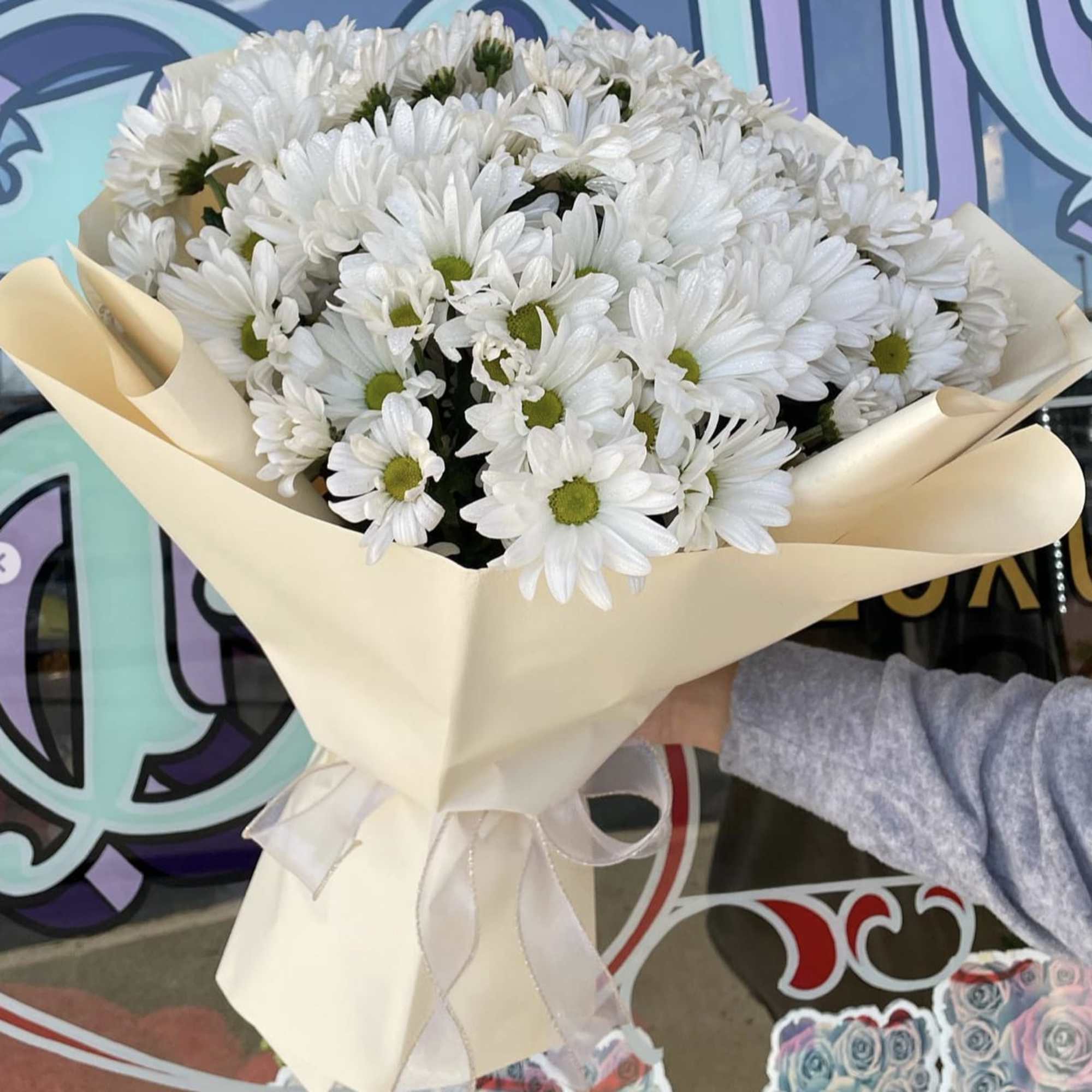 Bouquet of white daisies wrapped in cream paper with a ribbon, photo 2 of 2