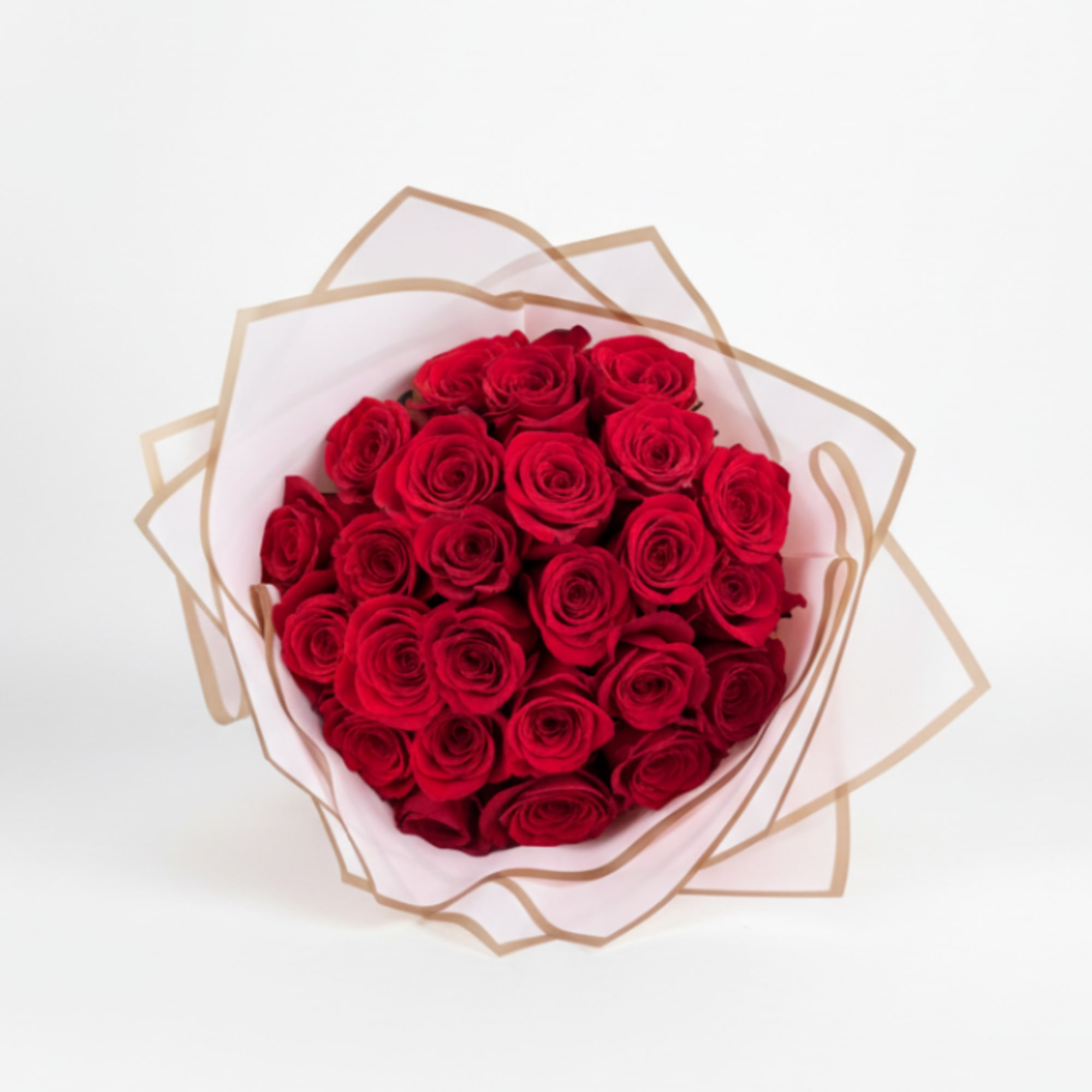 Round bouquet of red roses wrapped in white tissue and tan-edged paper