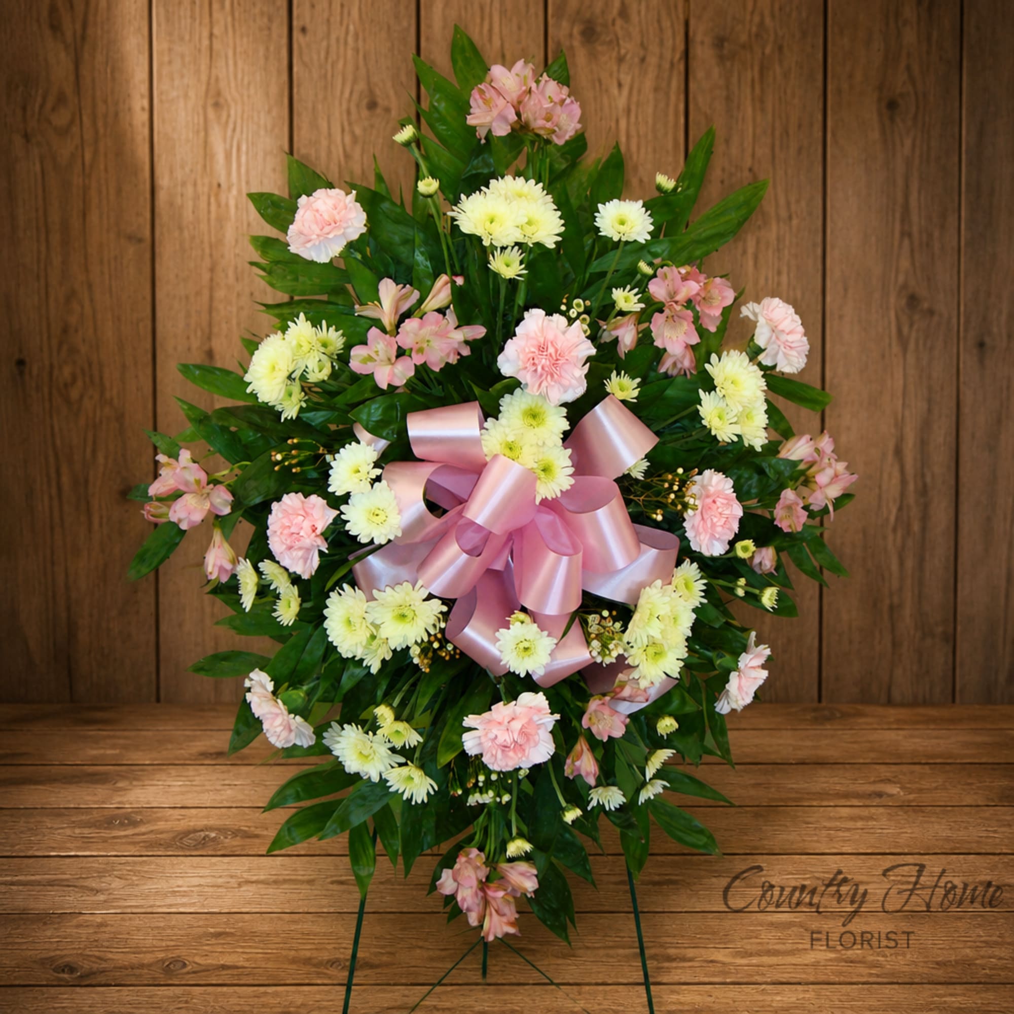 Pink and white floral standing spray with a satin ribbon bow