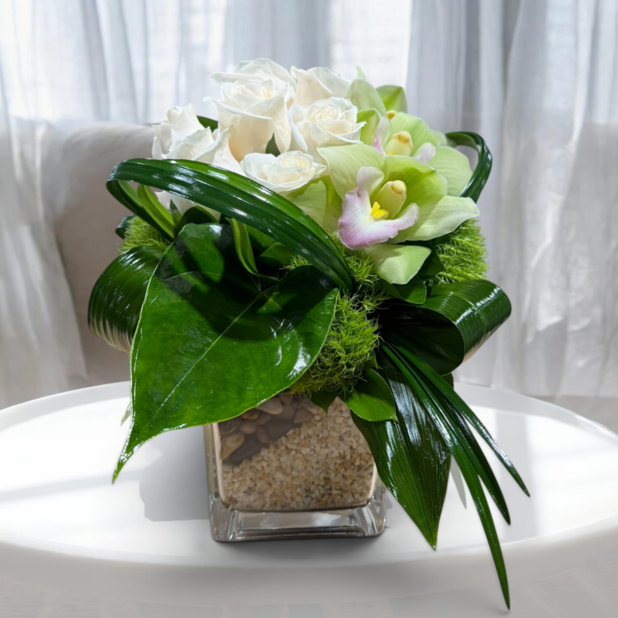 White roses and pale green orchids in a square glass vase, photo 3 of 7