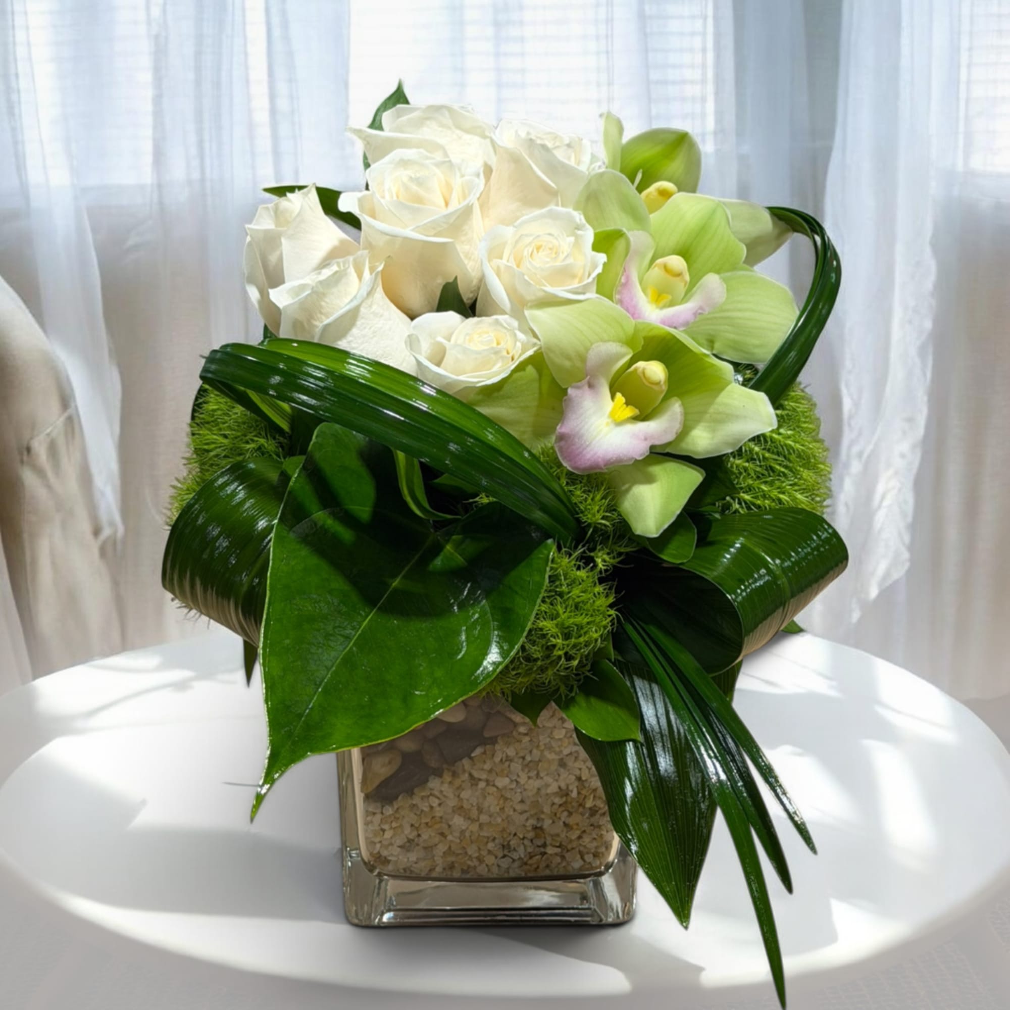 White roses and pale green orchids in a square glass vase, photo 4 of 7