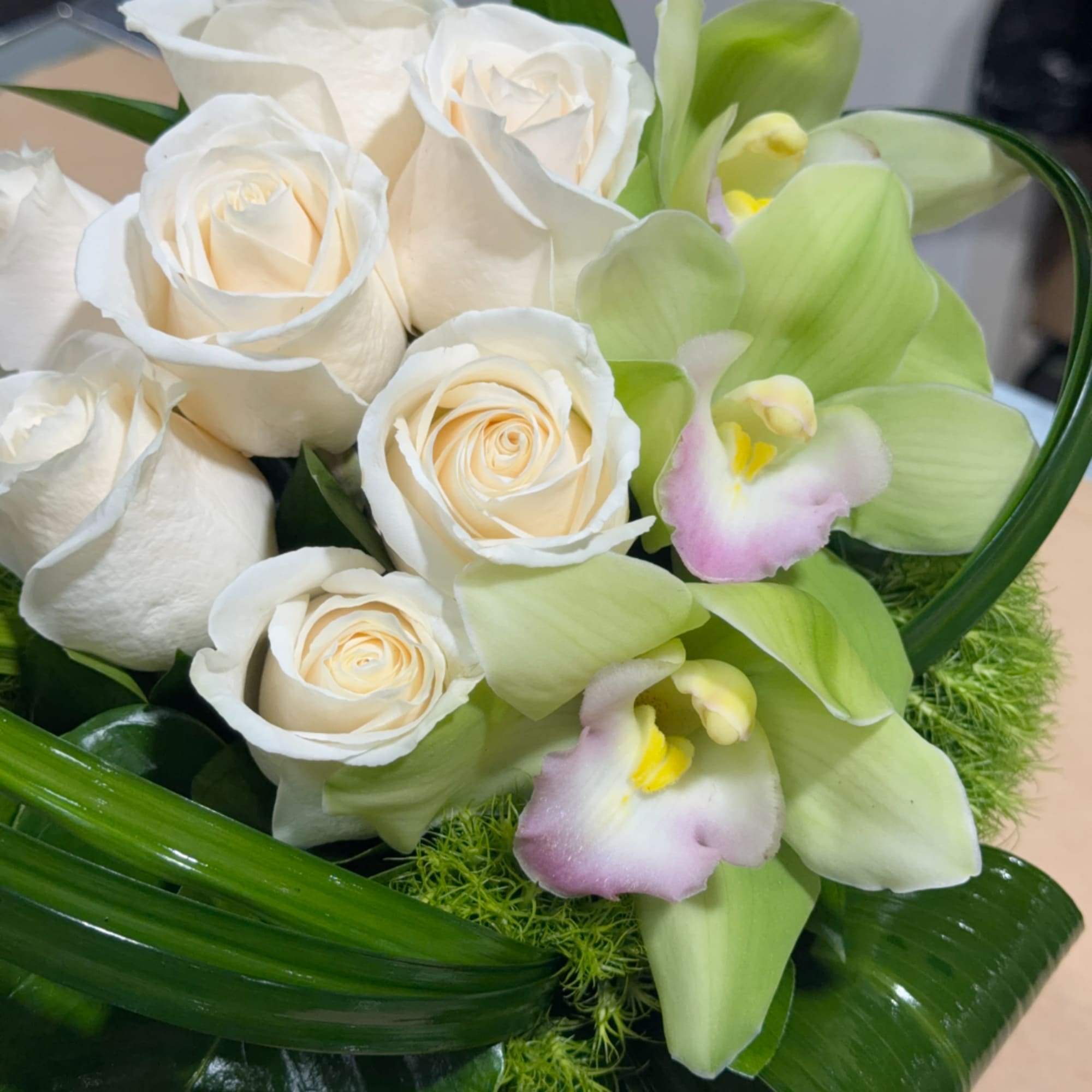 White roses and pale green orchids in a bouquet