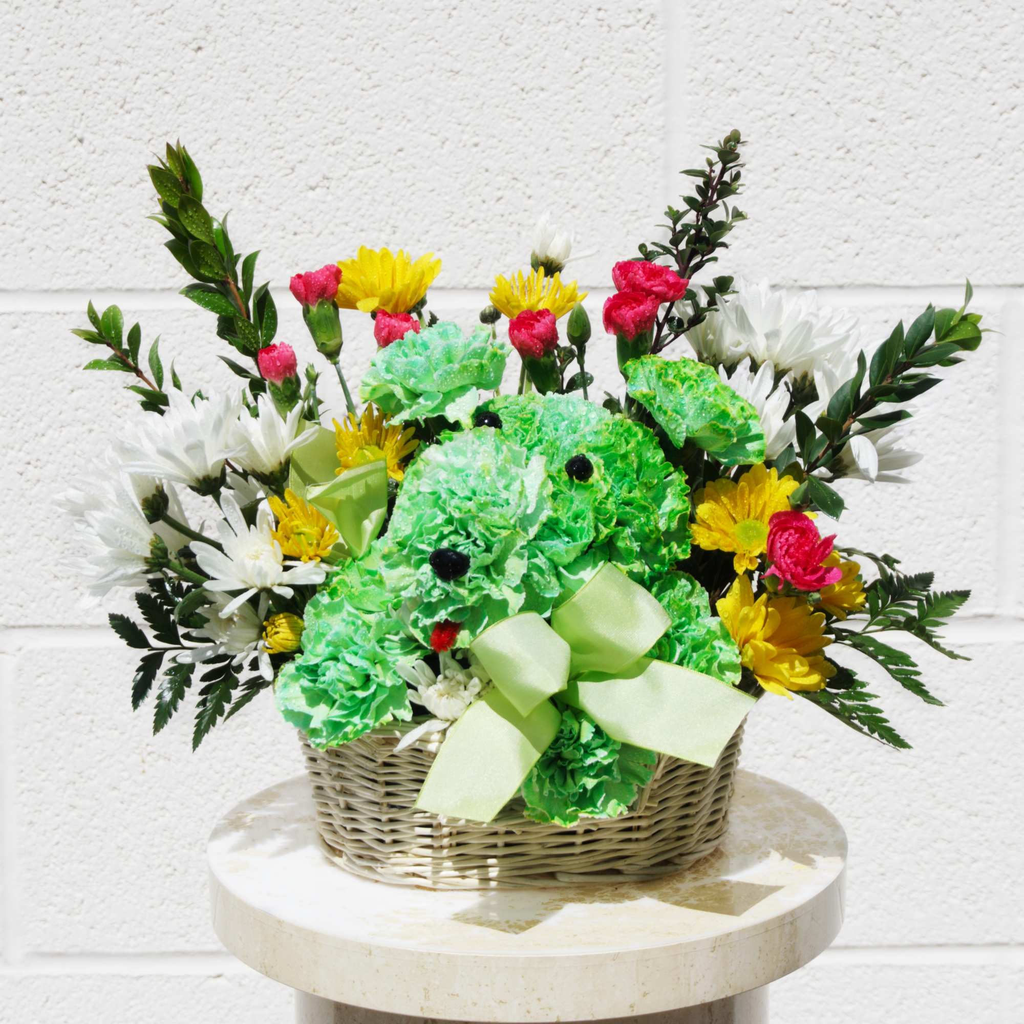 Basket arrangement with green teddy bear and mixed flowers