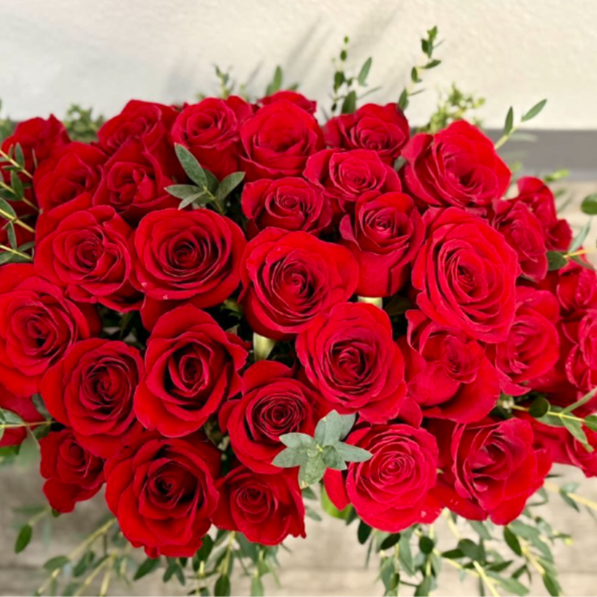 Large bouquet of red roses with scattered greenery