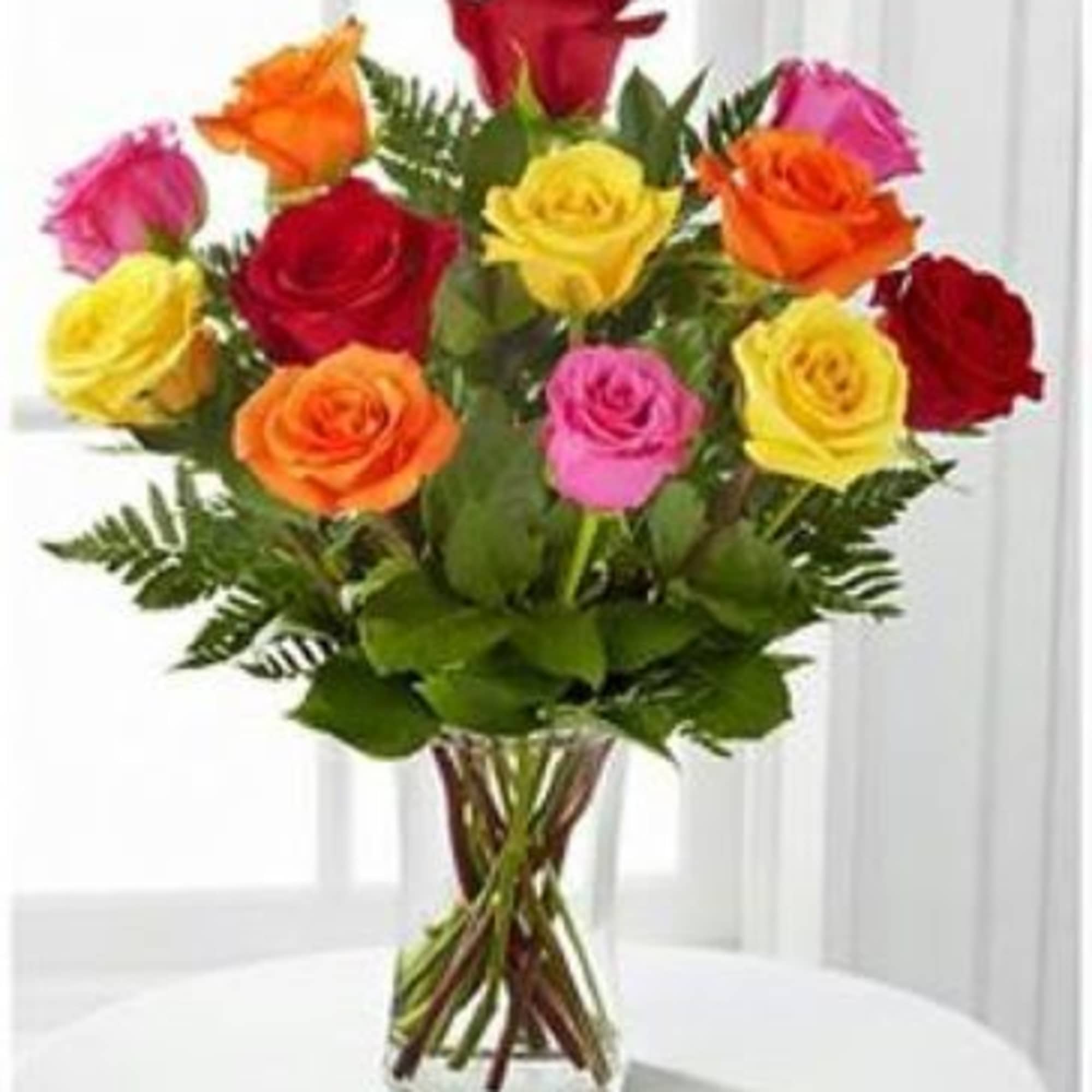 Bouquet of multicolored roses in a clear glass vase