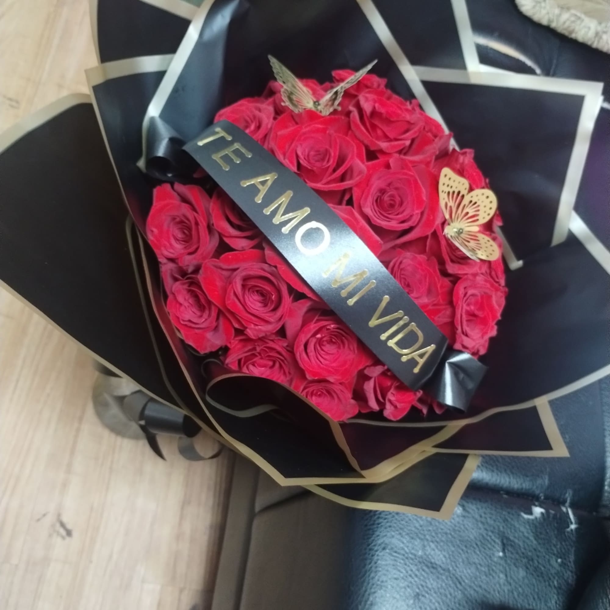 Bouquet of red roses wrapped in black paper with a ribbon