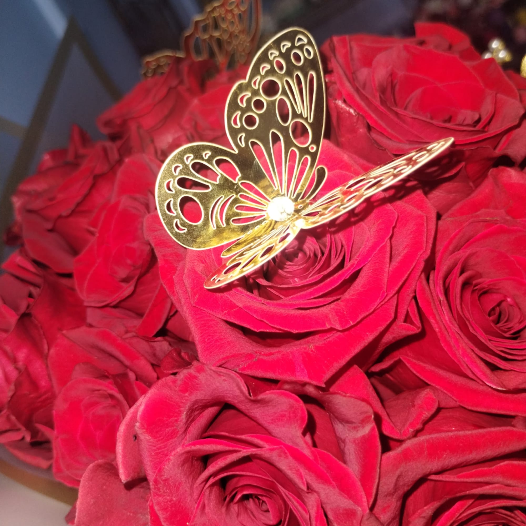 Red rose bouquet with a gold butterfly topper
