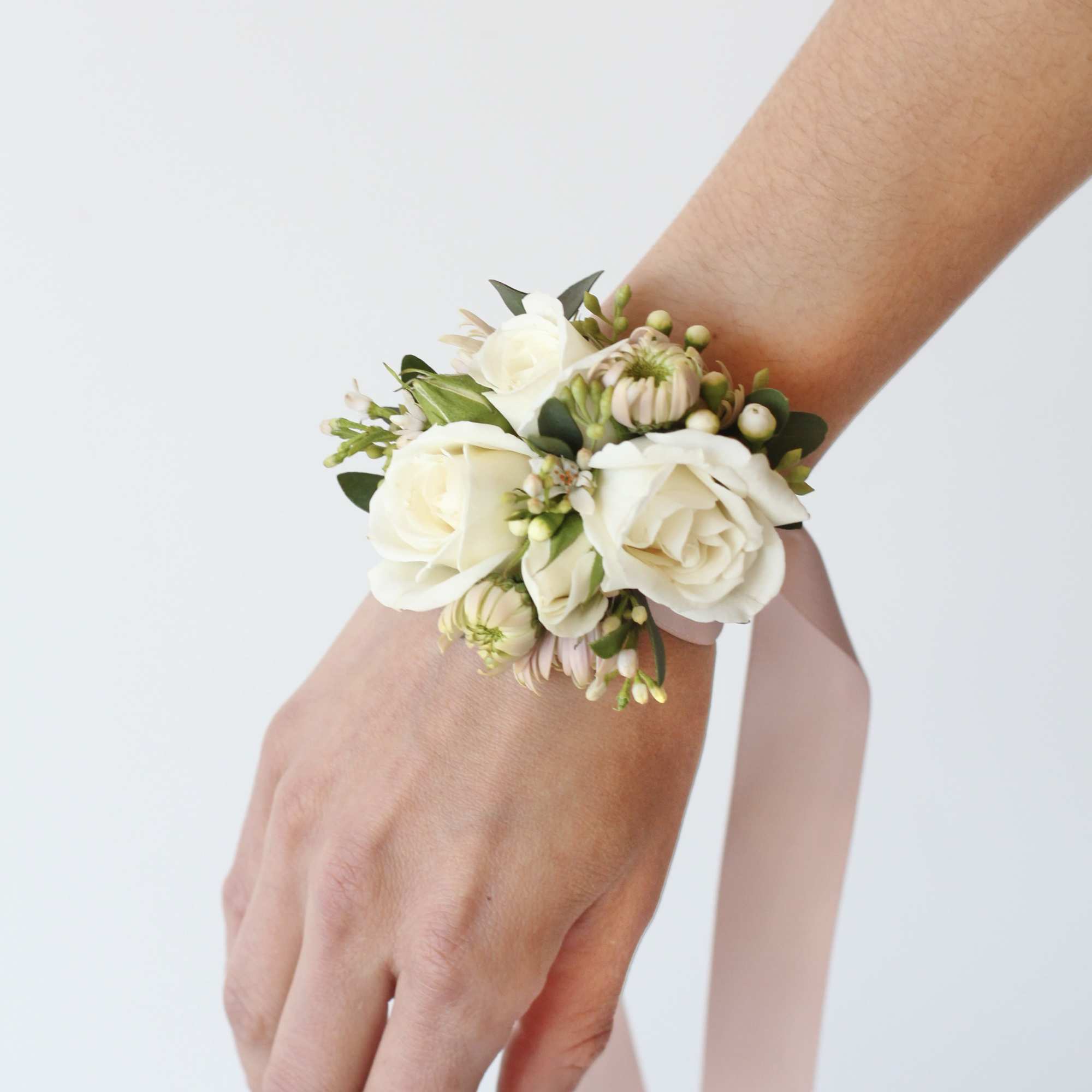 White rose wrist corsage with pale pink ribbon