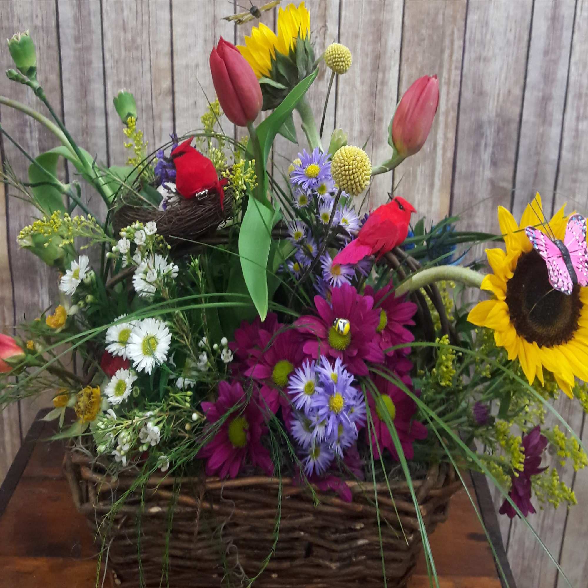 Mixed flower basket with sunflowers, tulips, daisies, and decorative birds