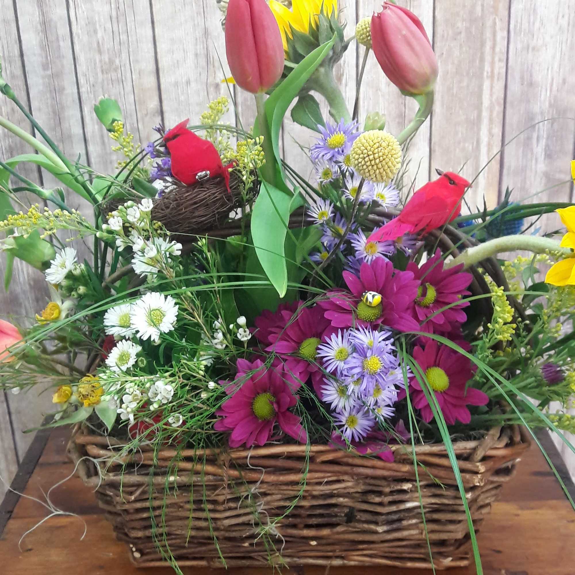 Basket arrangement with tulips, daisies, sunflowers, and decorative birds and butterfly