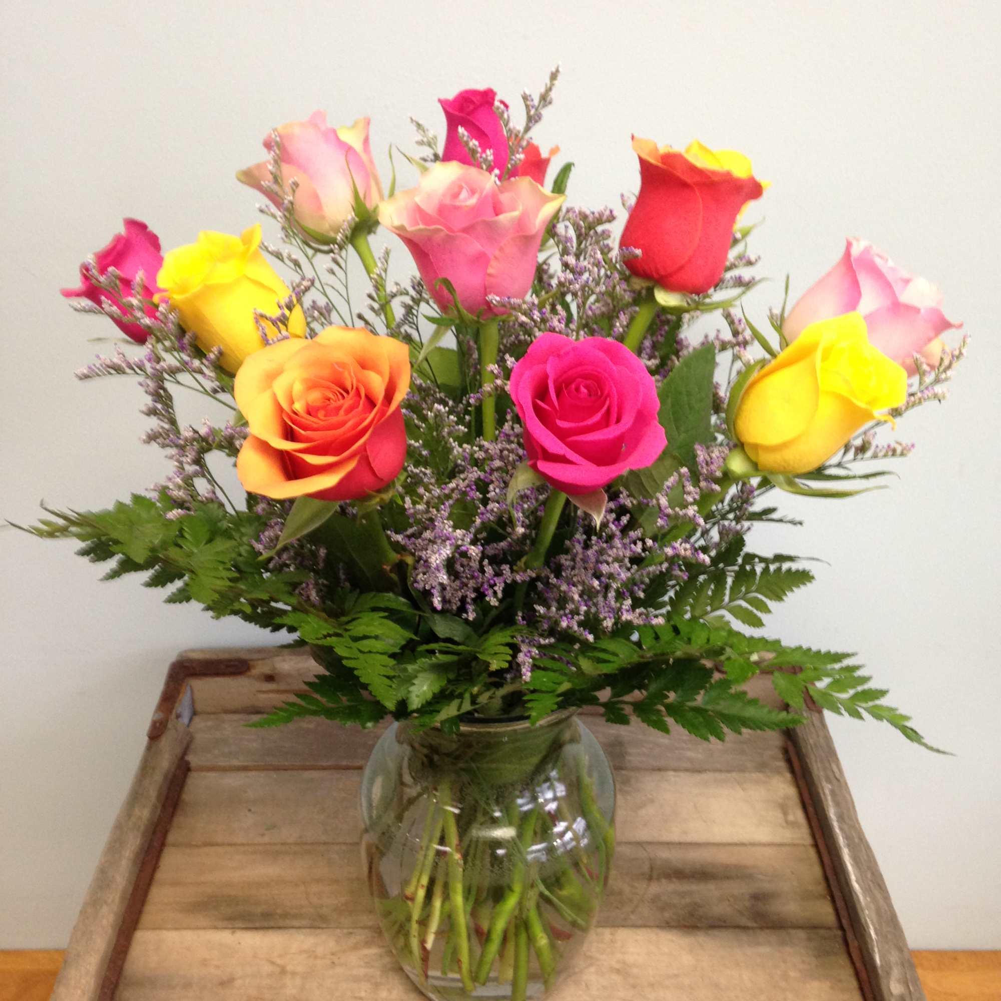 Mixed-color roses arranged in a clear glass vase