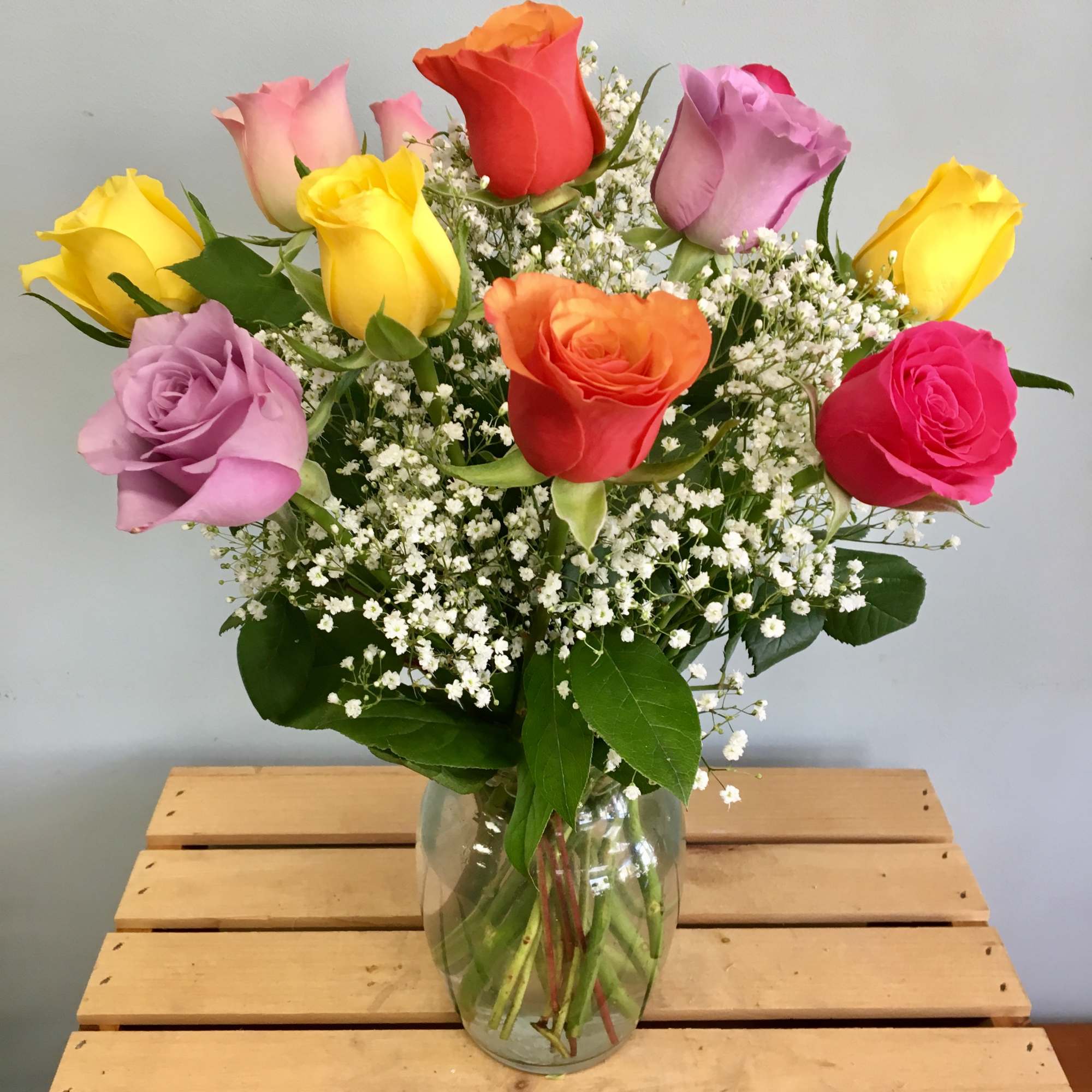 Colorful roses arranged in a clear glass vase