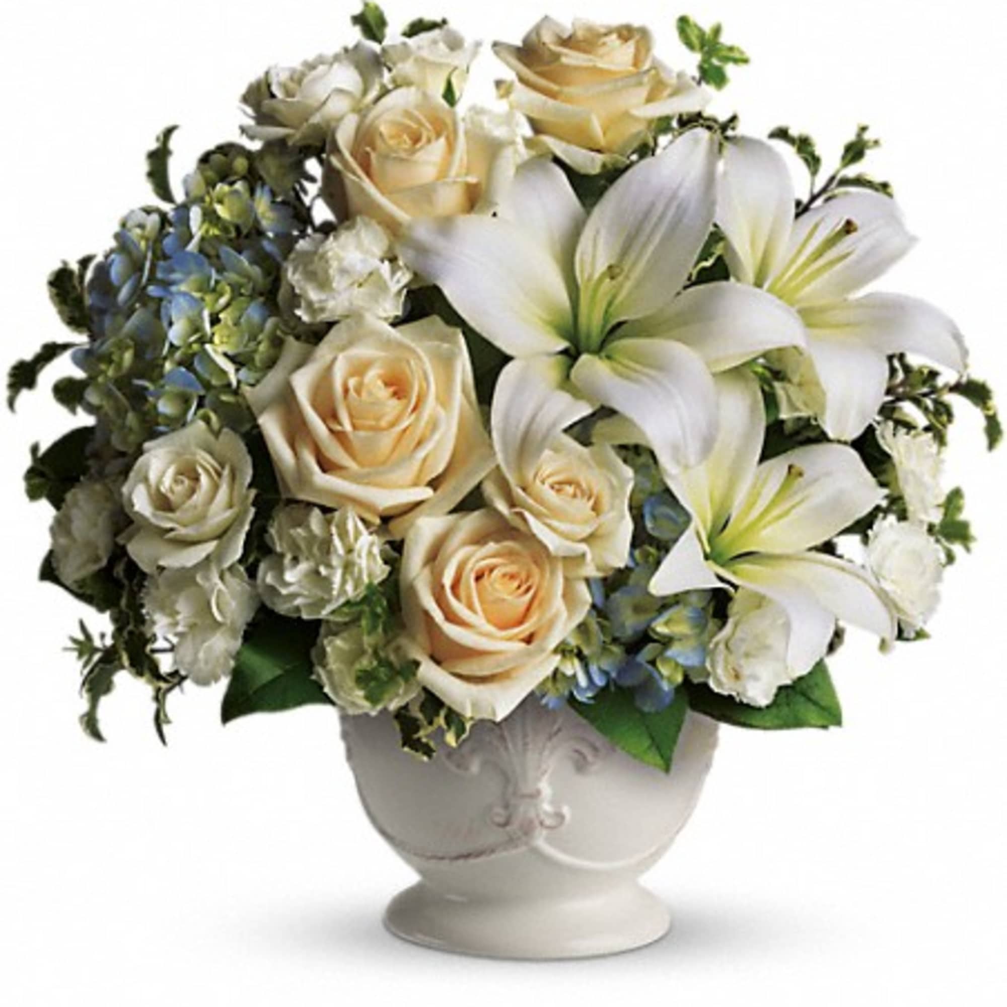 Cream roses and white lilies arranged in a white vase