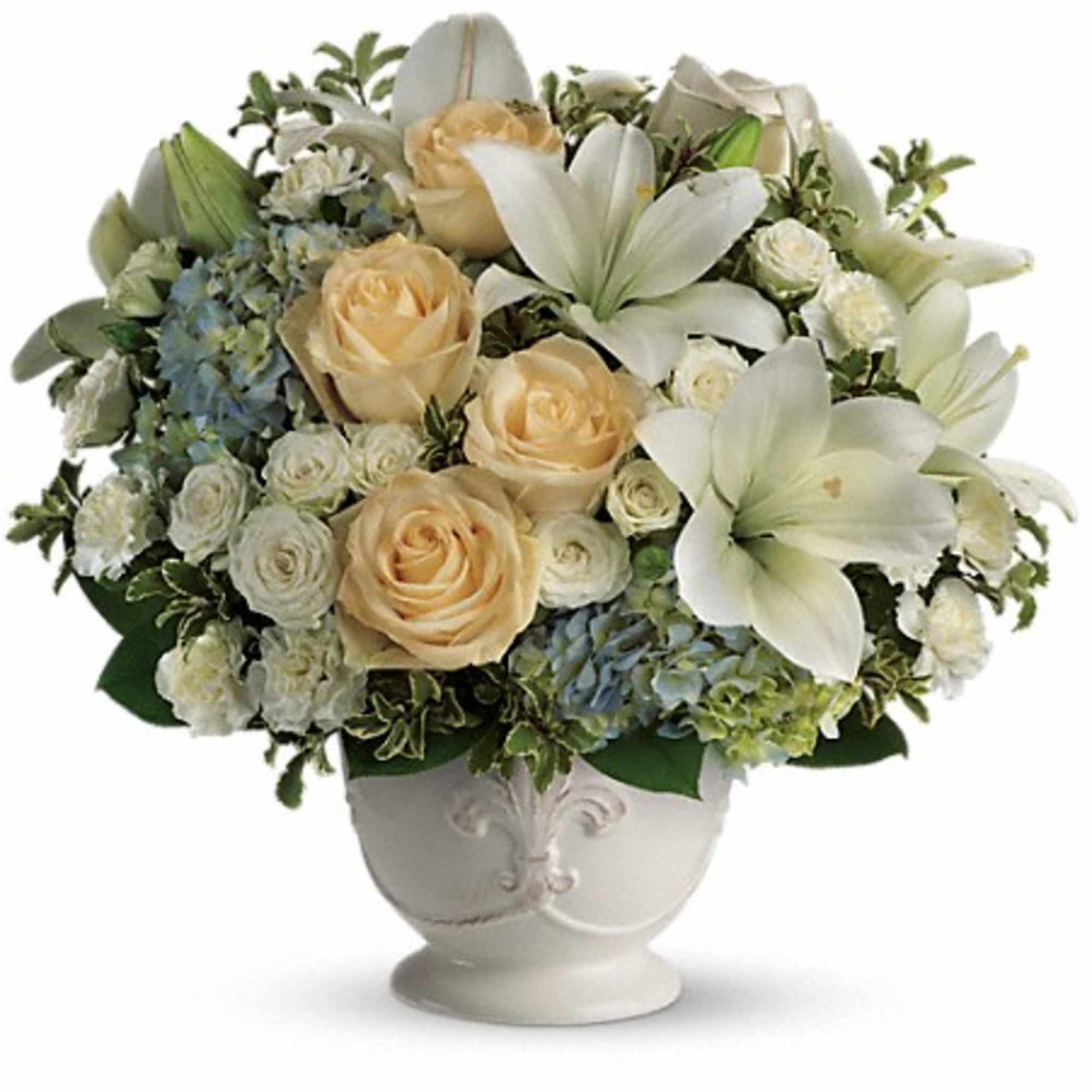 Cream roses and white lilies arranged in a white urn vase