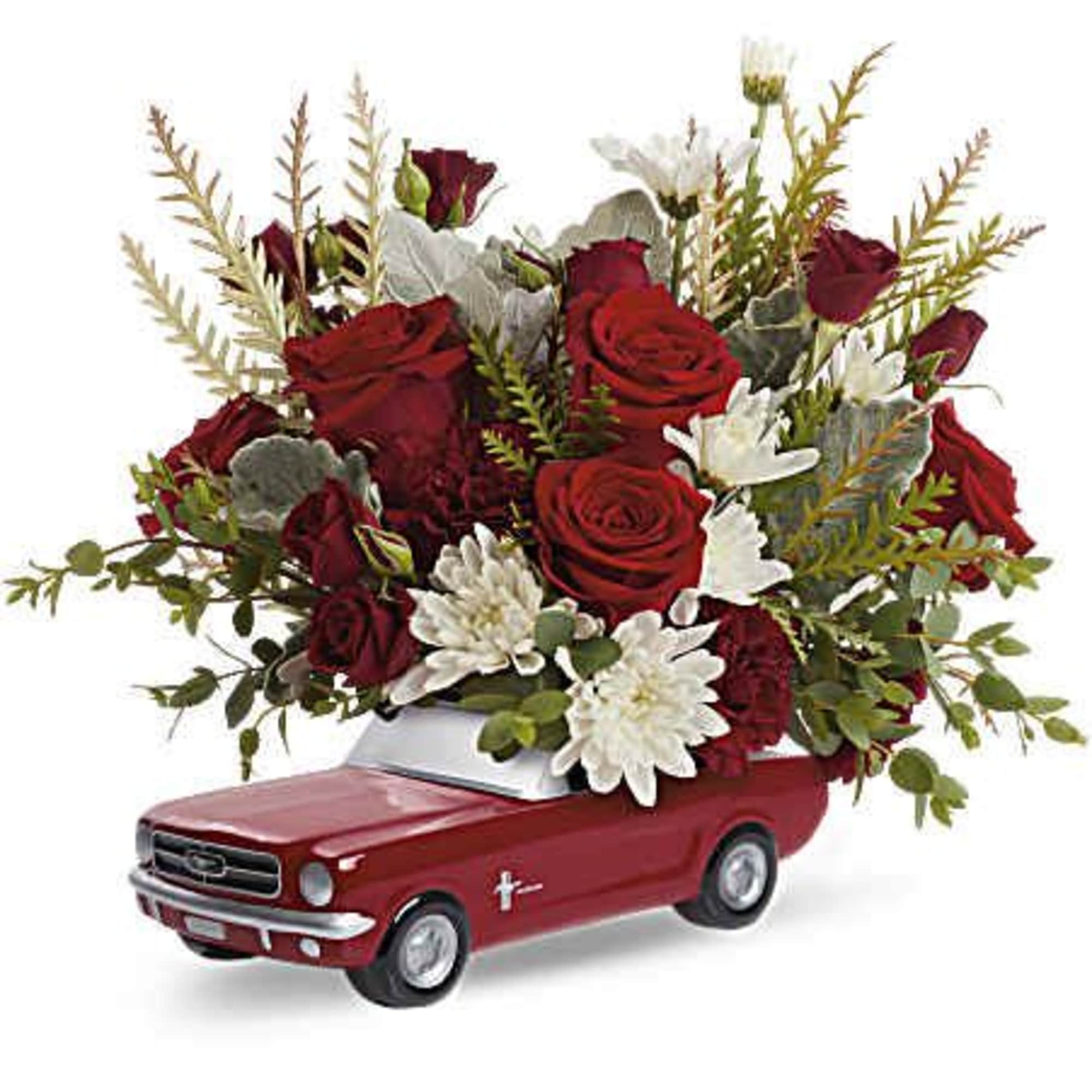 Red roses and white flowers arranged in a red toy car container