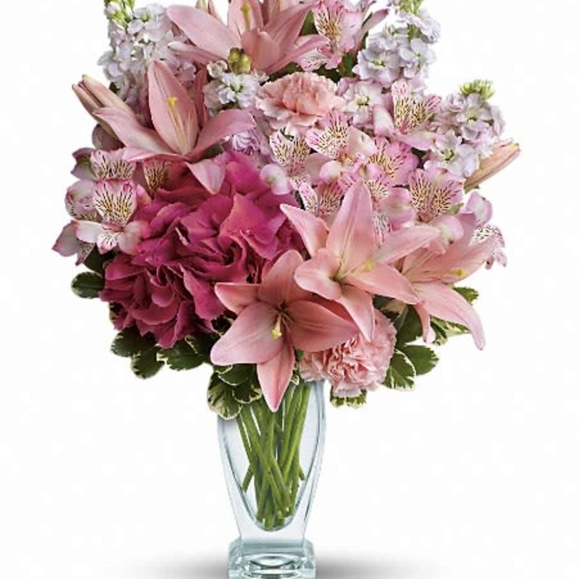 Pink lilies and mixed blooms arranged in a clear glass vase