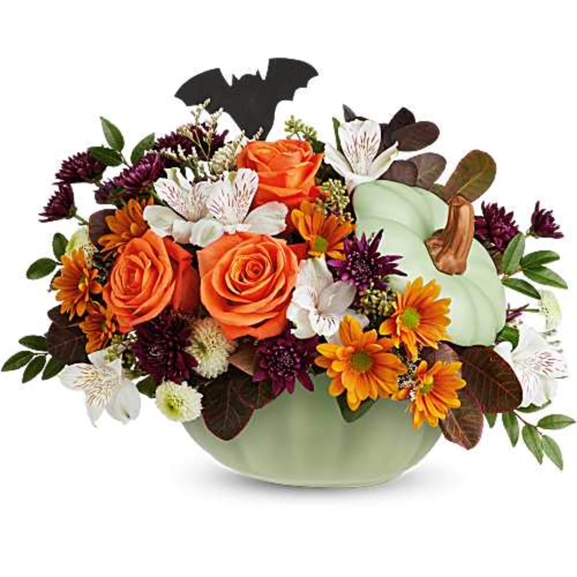 Orange roses and mixed fall flowers in a pale green pumpkin container with a bat pick