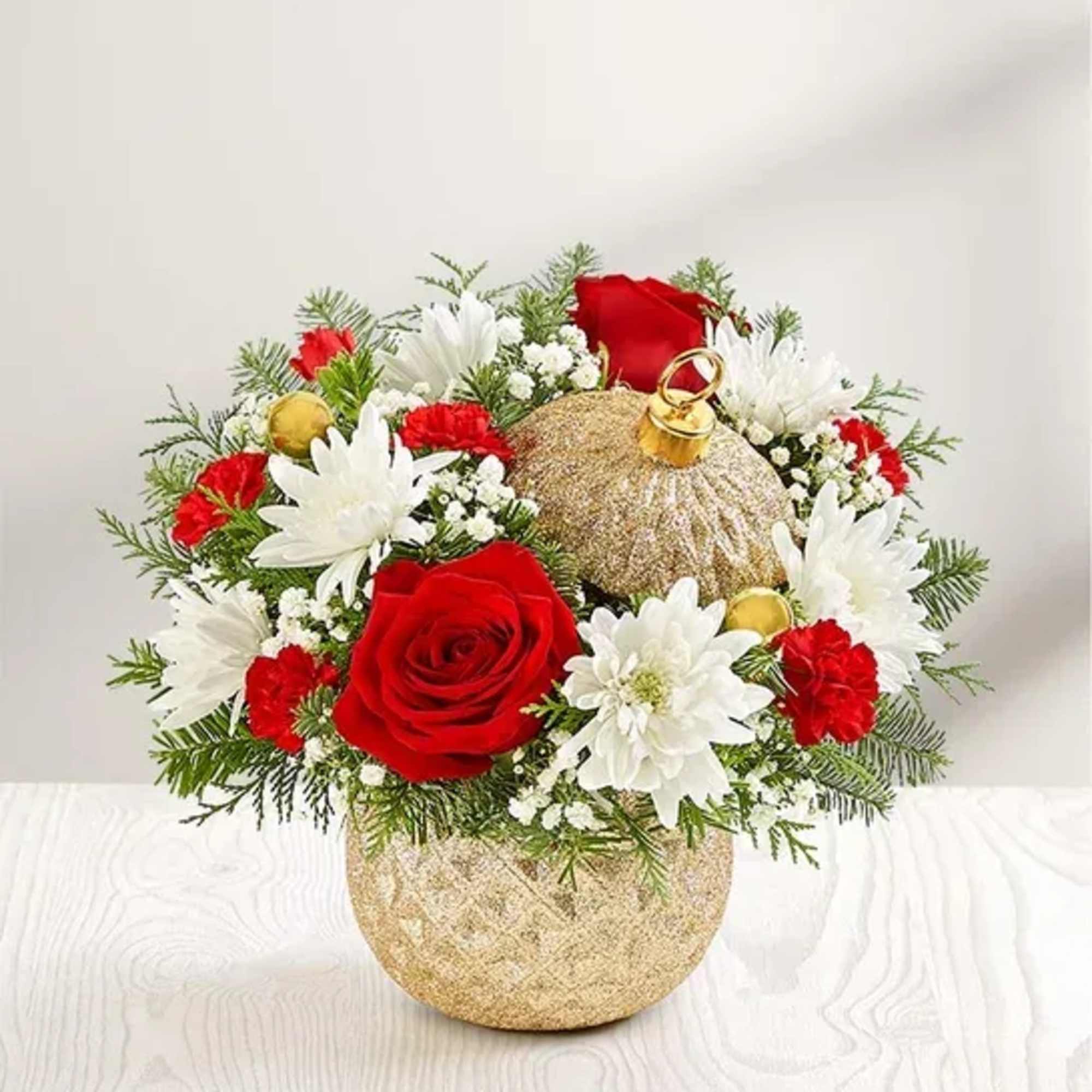 Red and white floral arrangement in a gold ornament-shaped vase