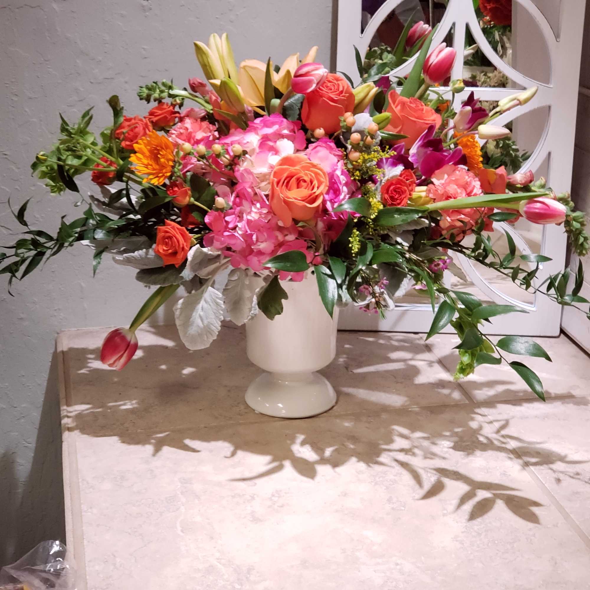 Colorful mixed flower arrangement in a white pedestal vase, photo 3 of 4