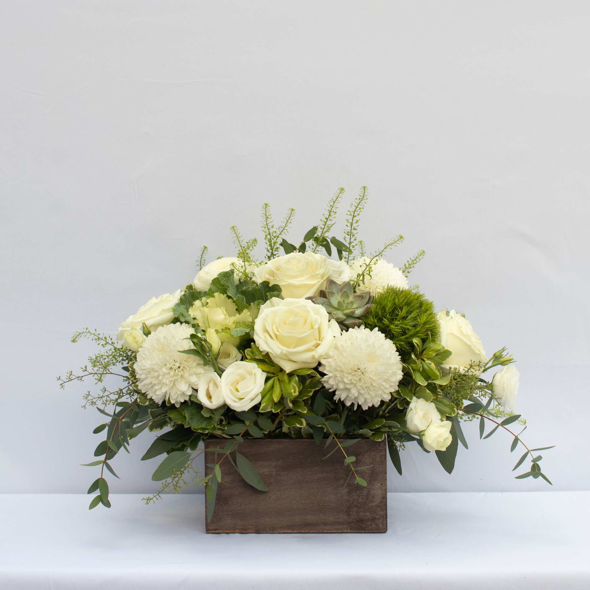 White roses and mums arranged in a wooden box