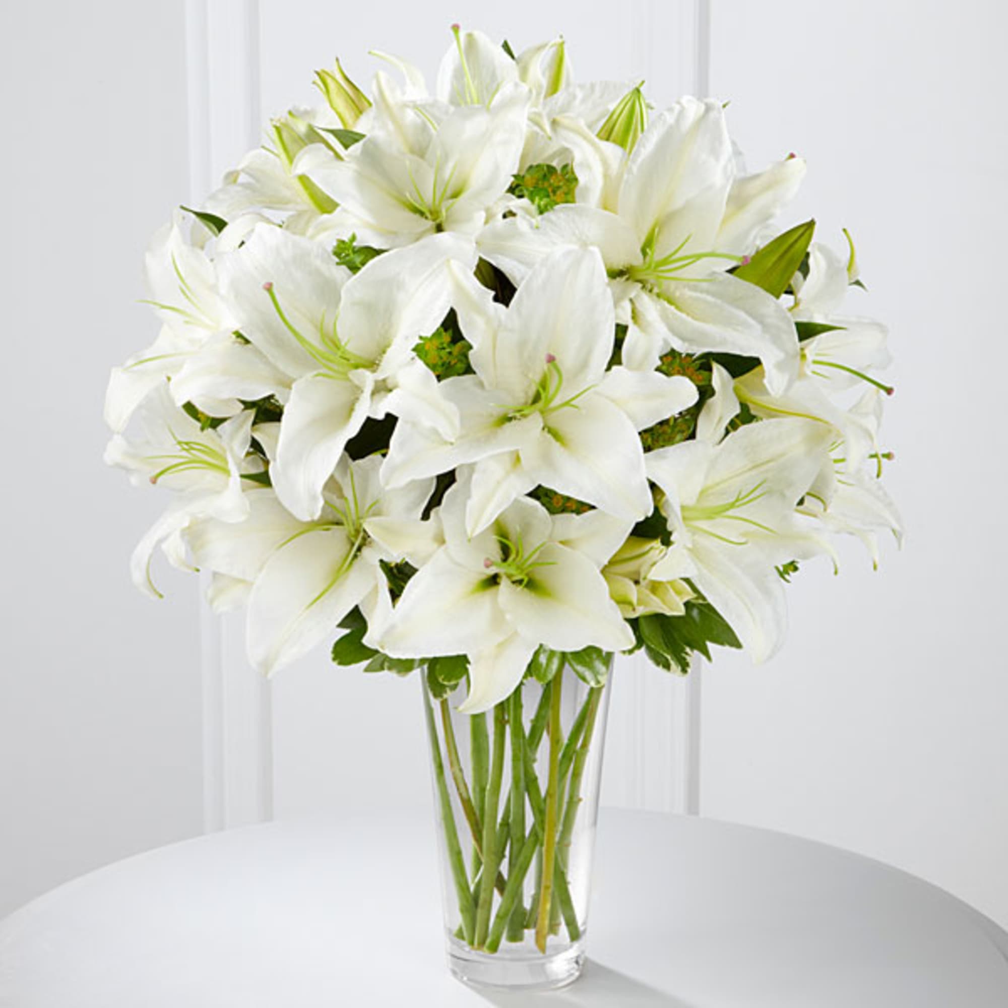 White lilies arranged in a clear glass vase, photo 2 of 2