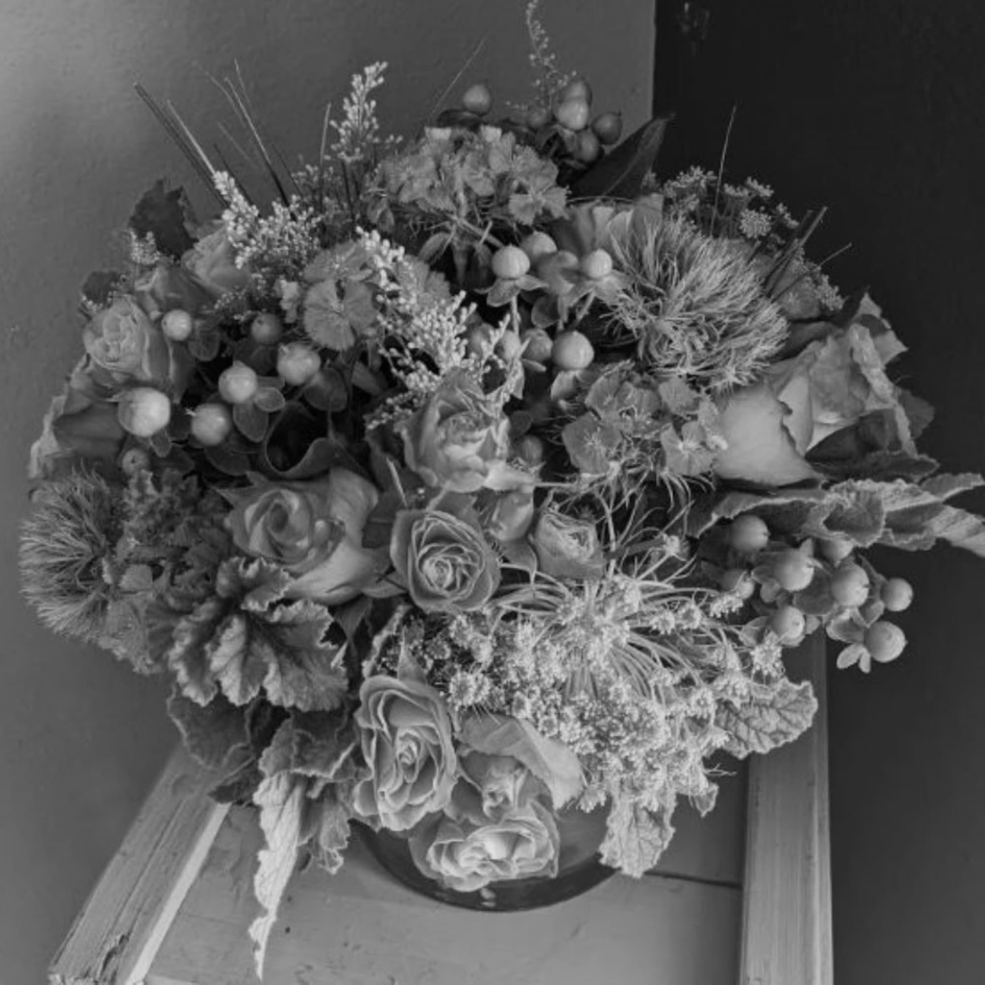 Large floral arrangement with roses and textured filler in a vase