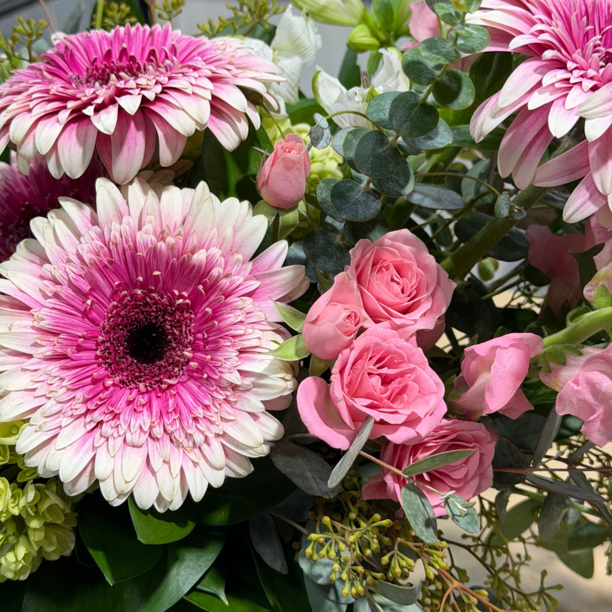 Pink gerbera daisies and roses in a mixed bouquet