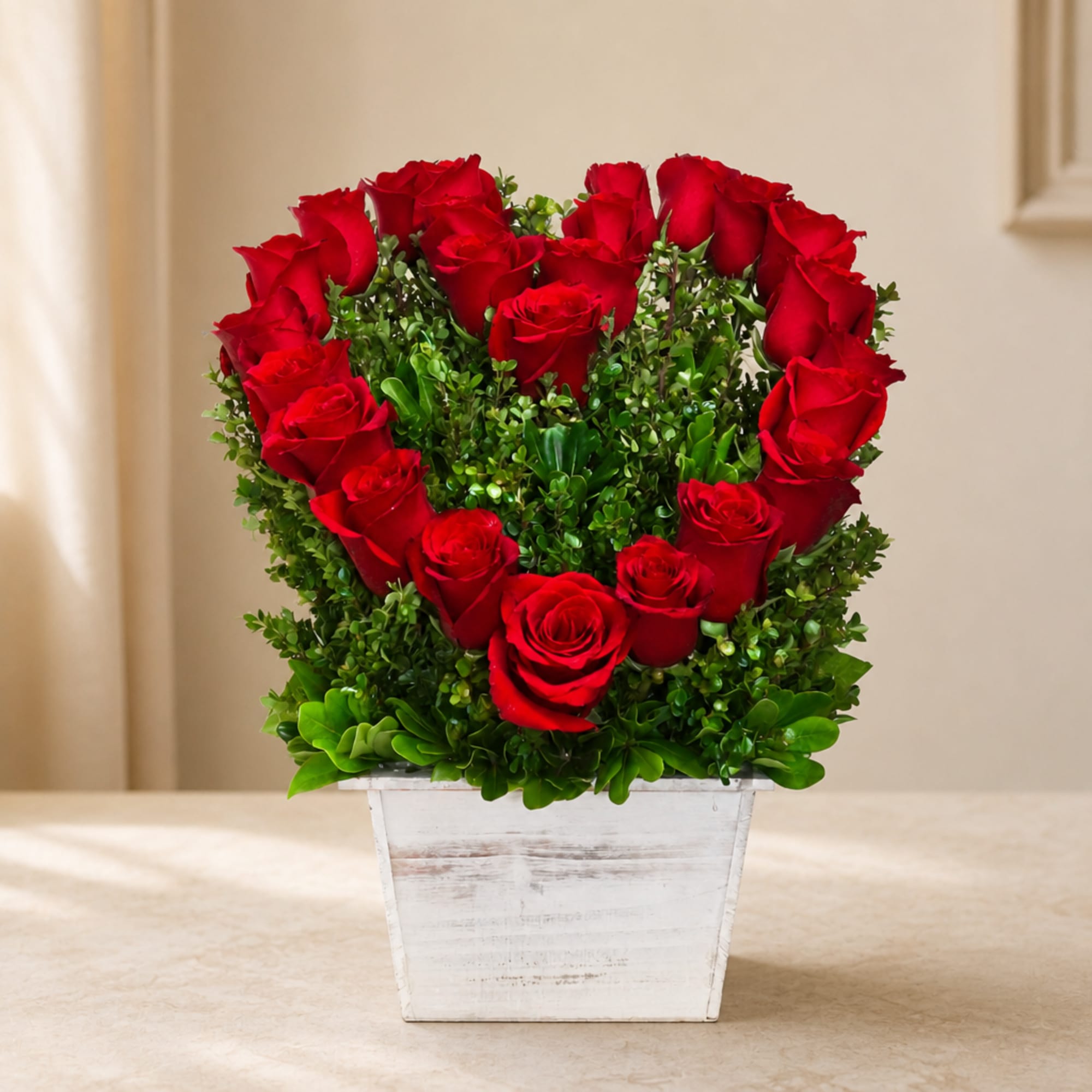 Red roses arranged in a white wooden planter