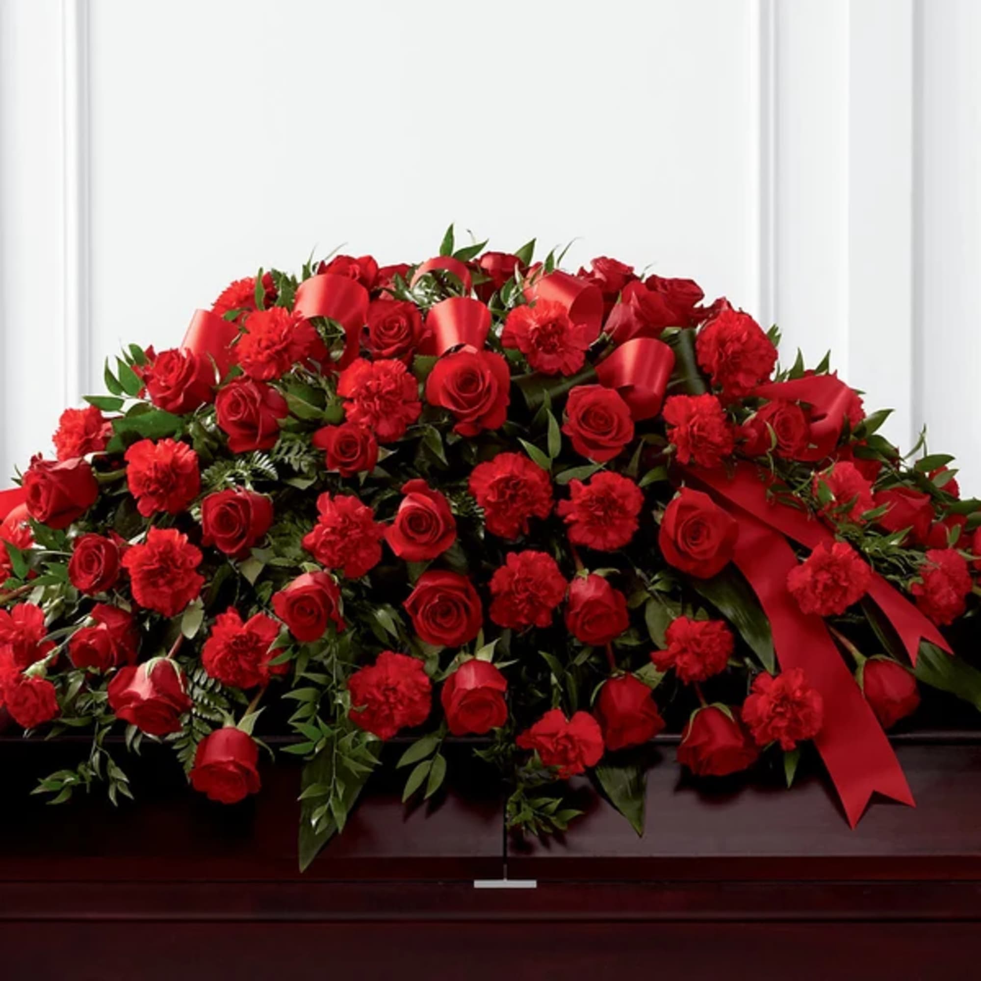 Large red rose and carnation casket spray with red ribbon