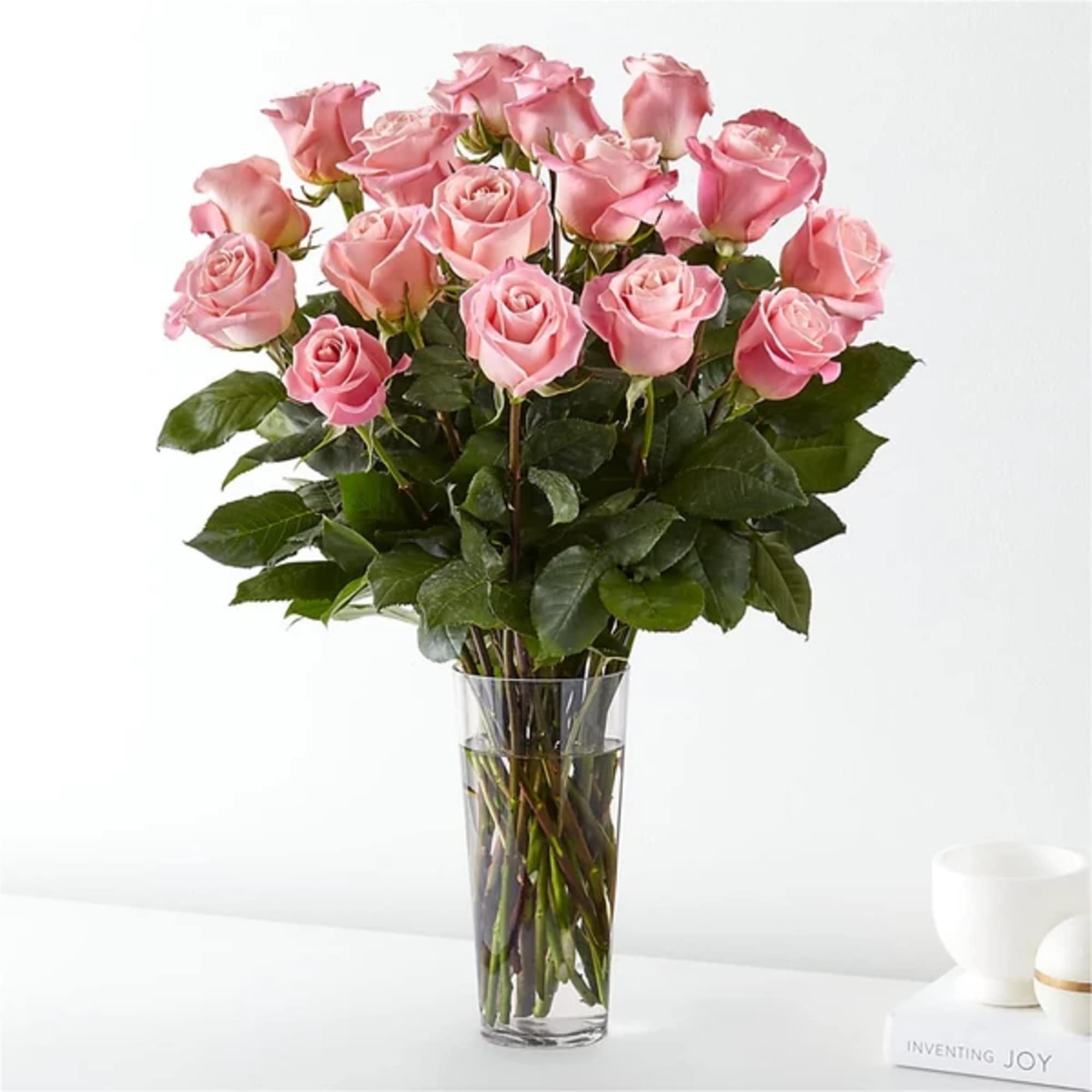 Pink roses arranged in a clear glass vase
