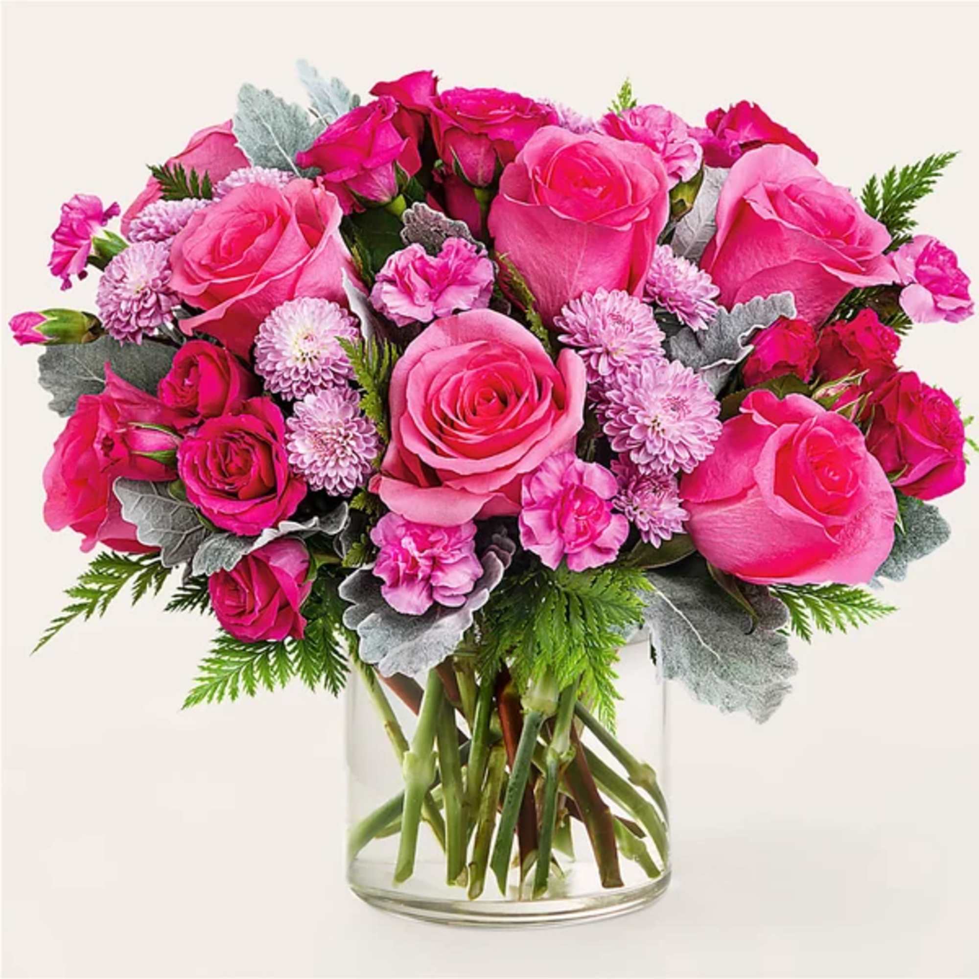 Pink roses and small pink blooms arranged in a clear glass vase