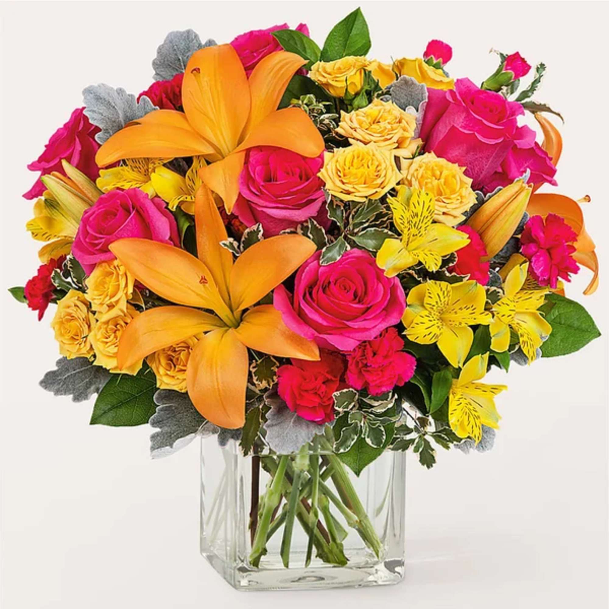 Bright bouquet of orange lilies, pink roses, and yellow flowers in a clear glass vase