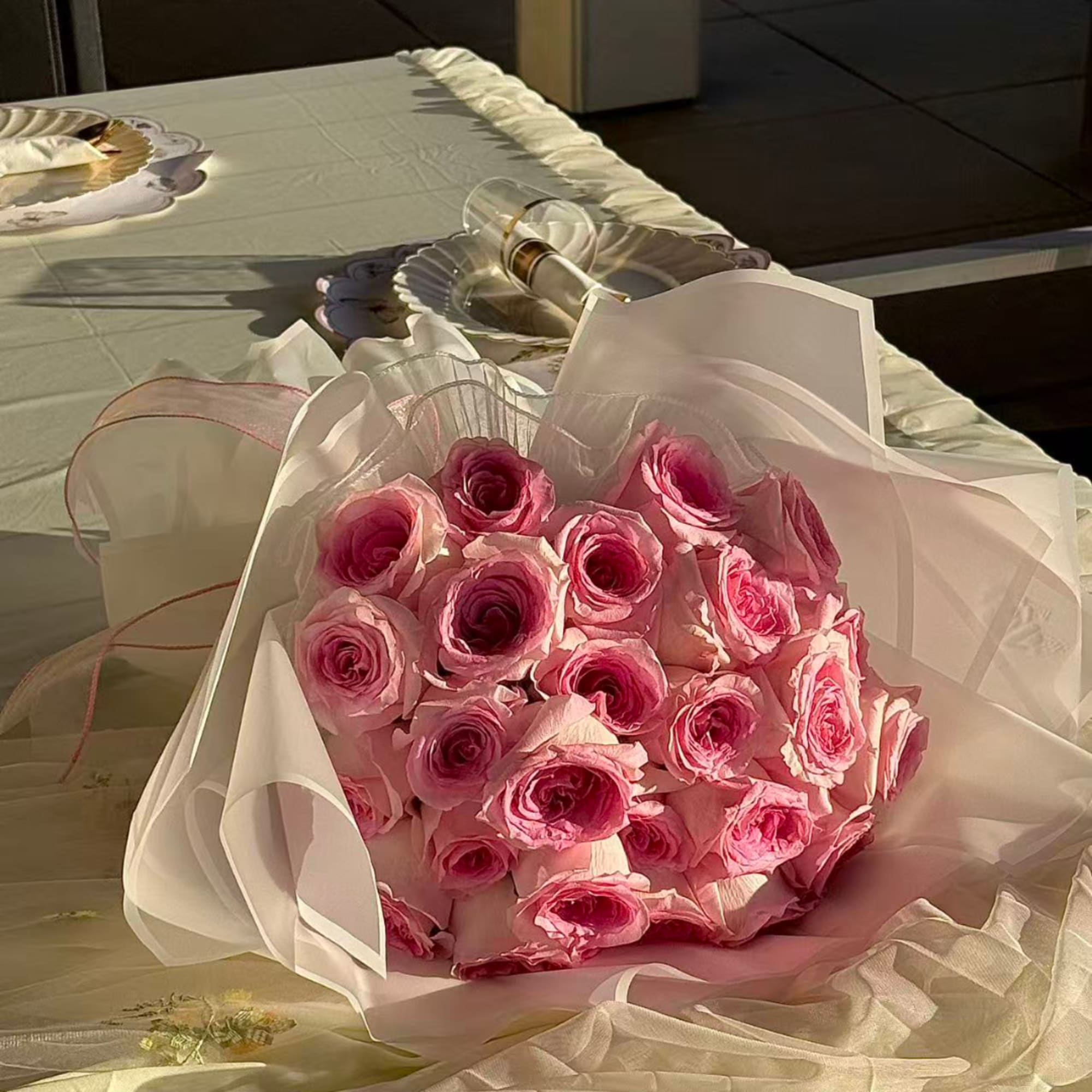 Bouquet of pink roses wrapped in pale paper