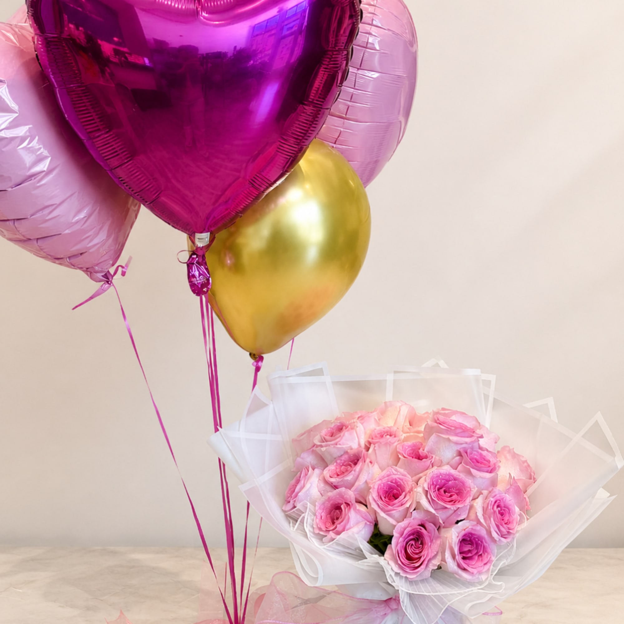 Pink rose bouquet with metallic heart balloons and a gold balloon