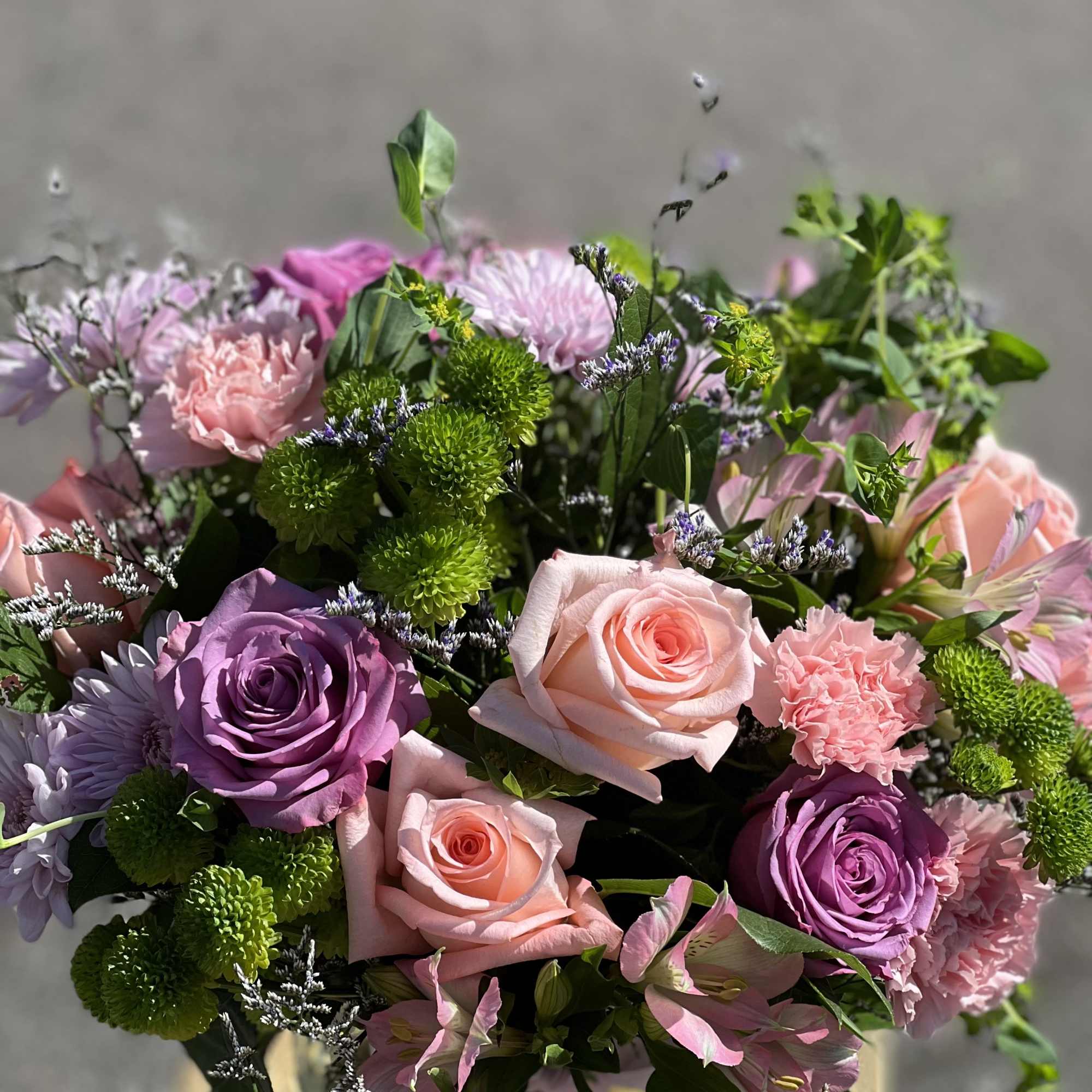 Bouquet of pink and purple roses with green button mums