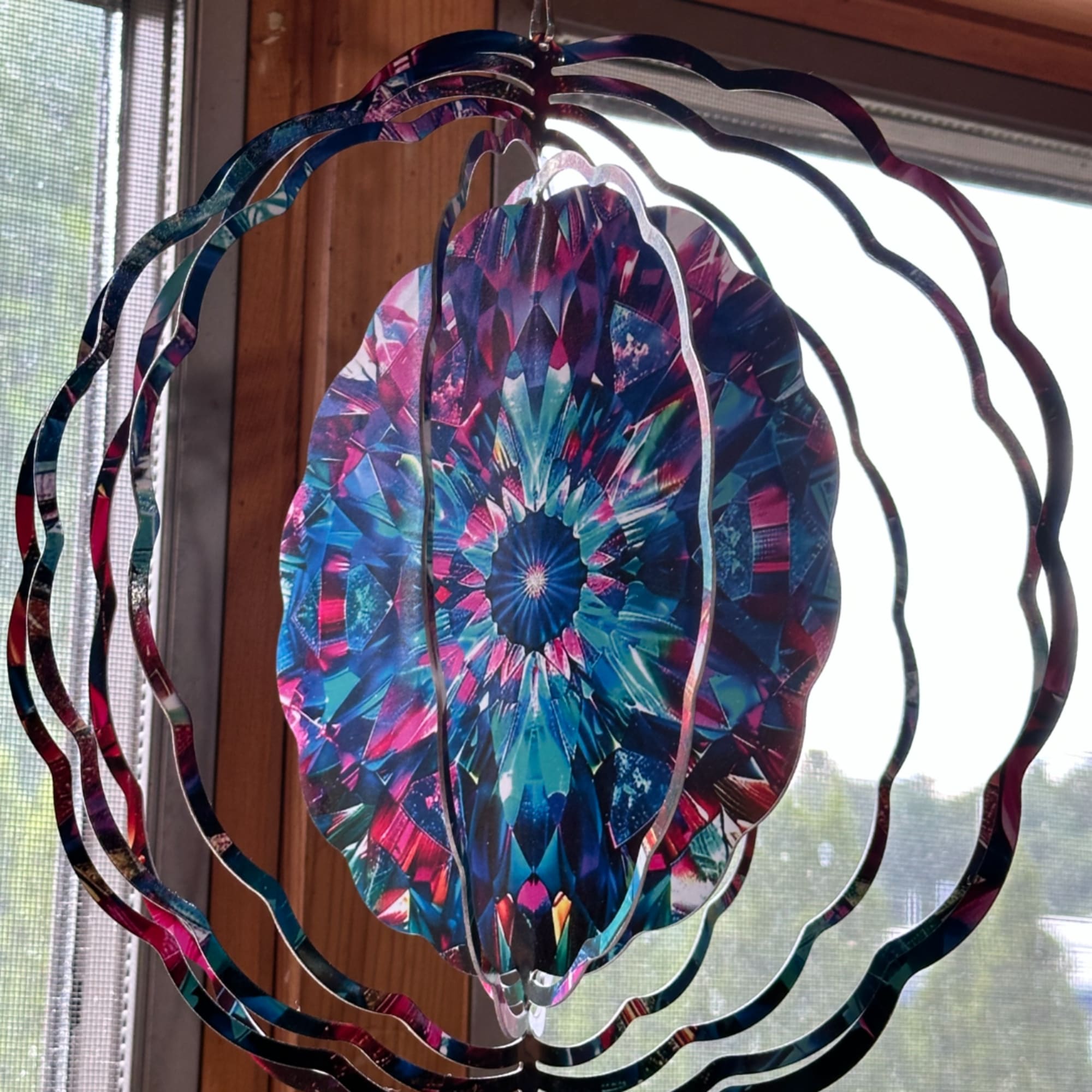 Colorful hanging mobile with layered oval rings and a patterned center disc