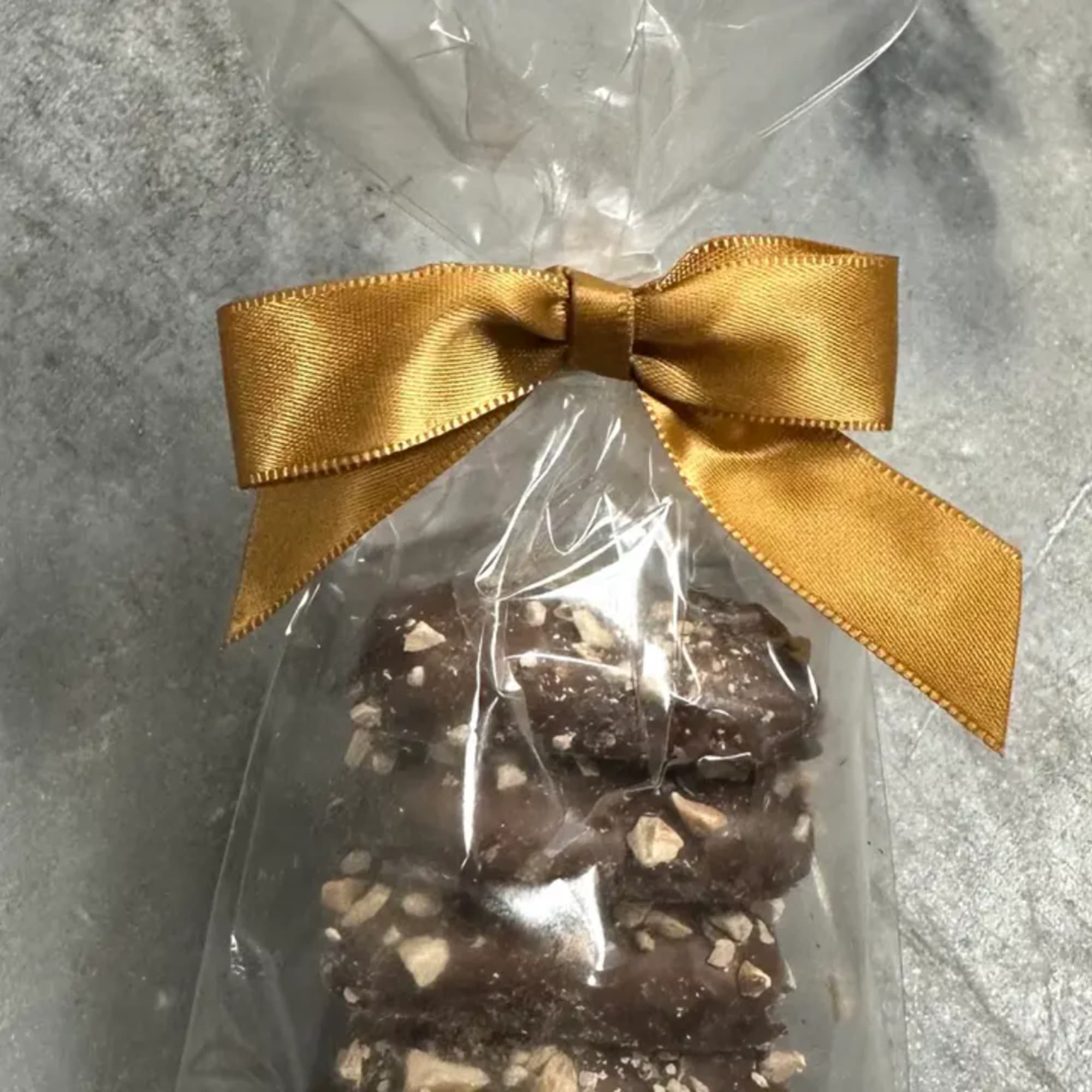 Bag of chocolate-covered nut candies tied with a gold ribbon