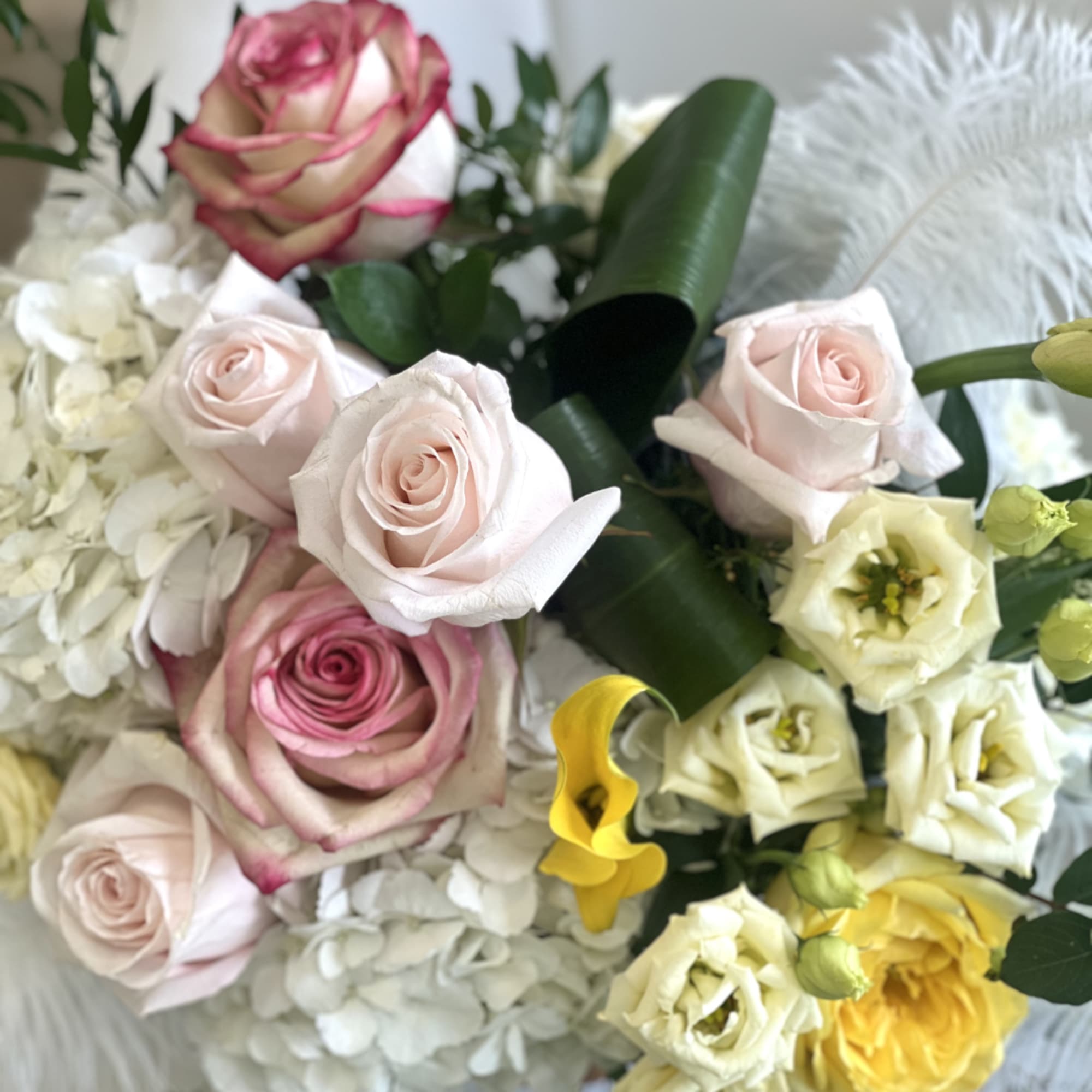 Bouquet of pale pink and white roses with white hydrangeas and yellow blooms