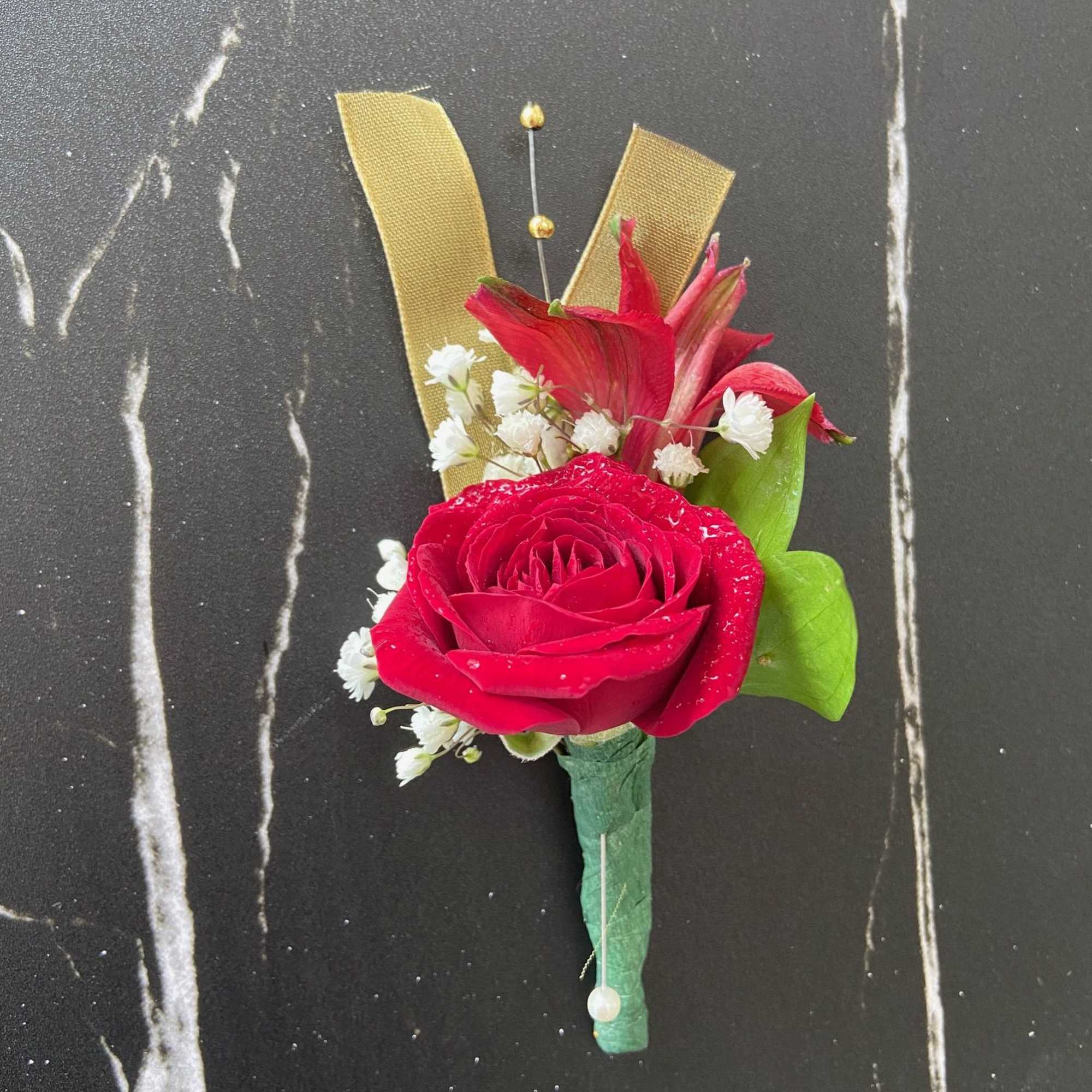 Red rose boutonniere with white baby's breath and gold ribbon