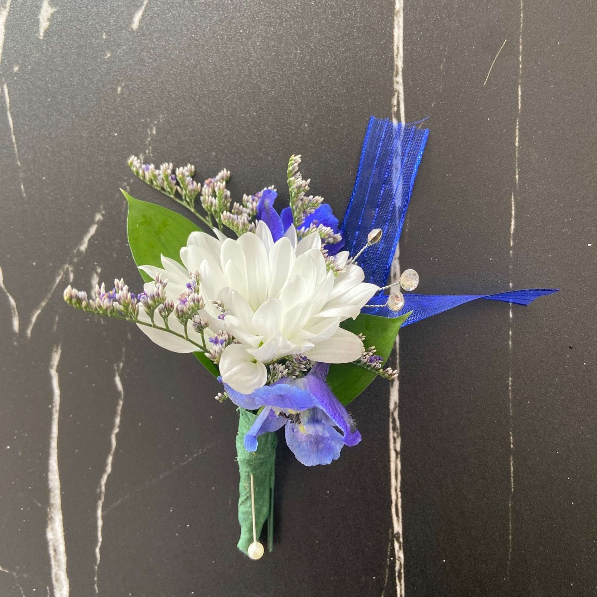 White and blue boutonniere with ribbon accents